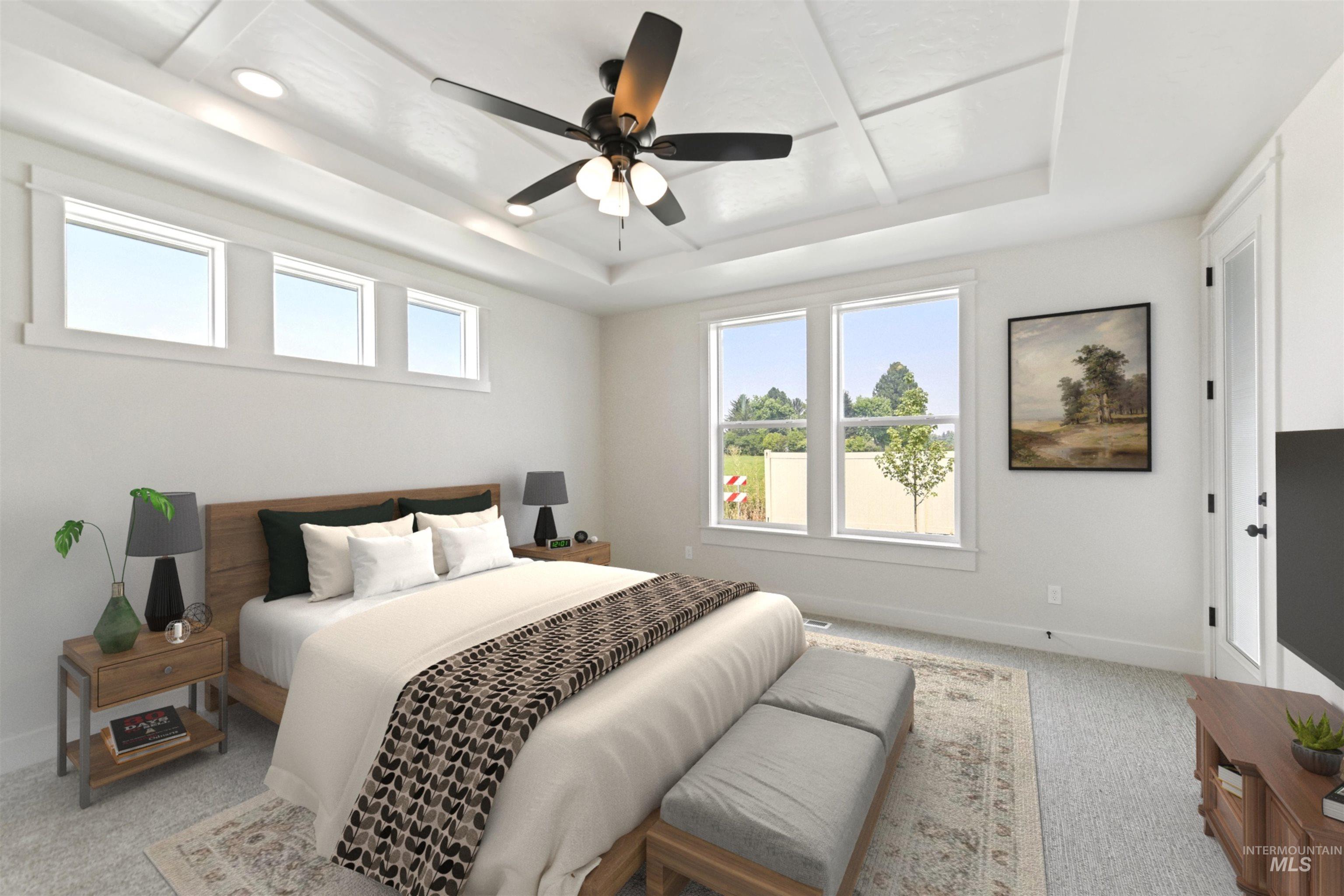 Bedroom featuring a raised ceiling, light carpet, and a ceiling fan