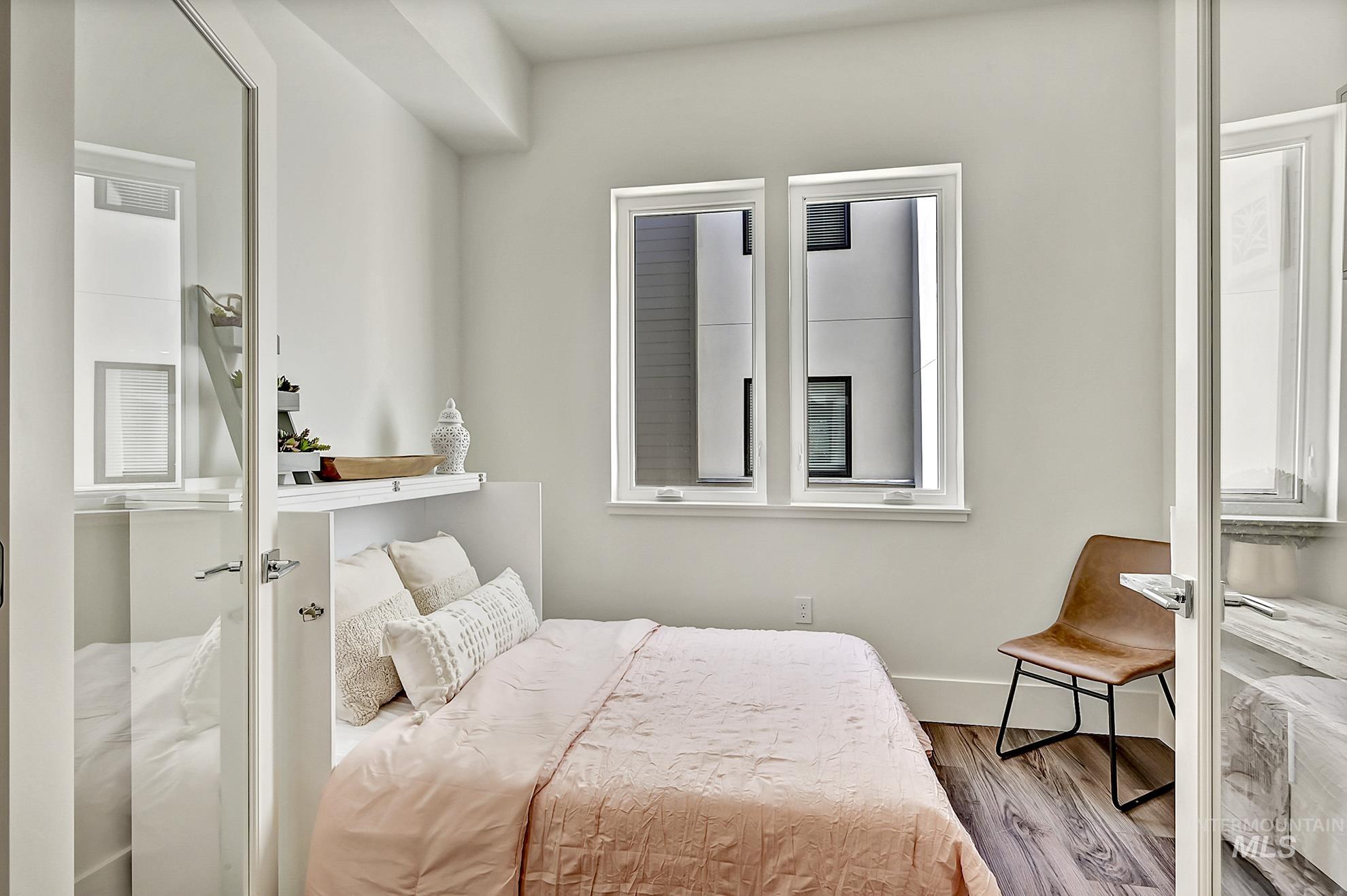 Bedroom with wood finished floors and baseboards