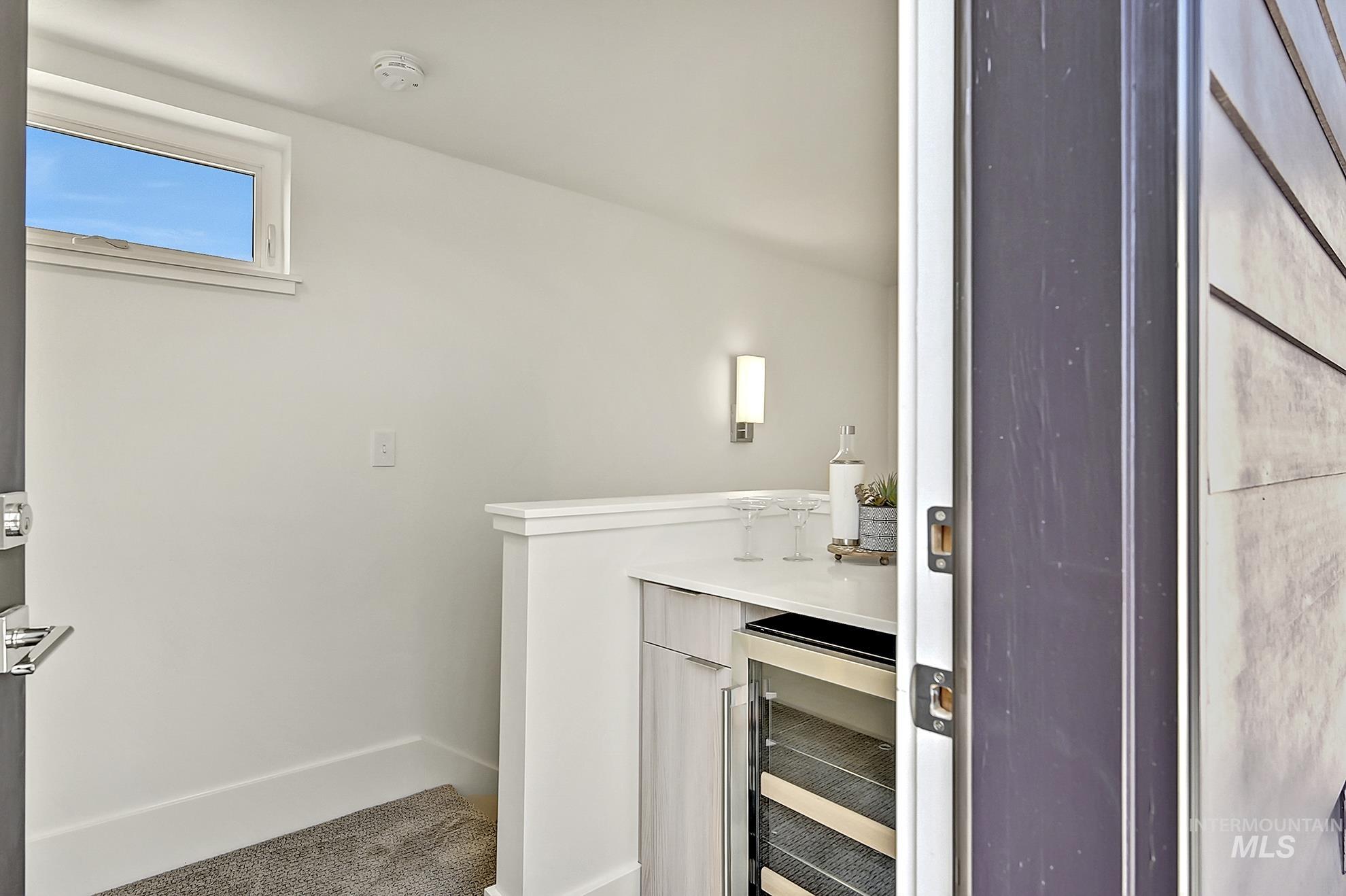 Bar area featuring wine cooler and light countertops