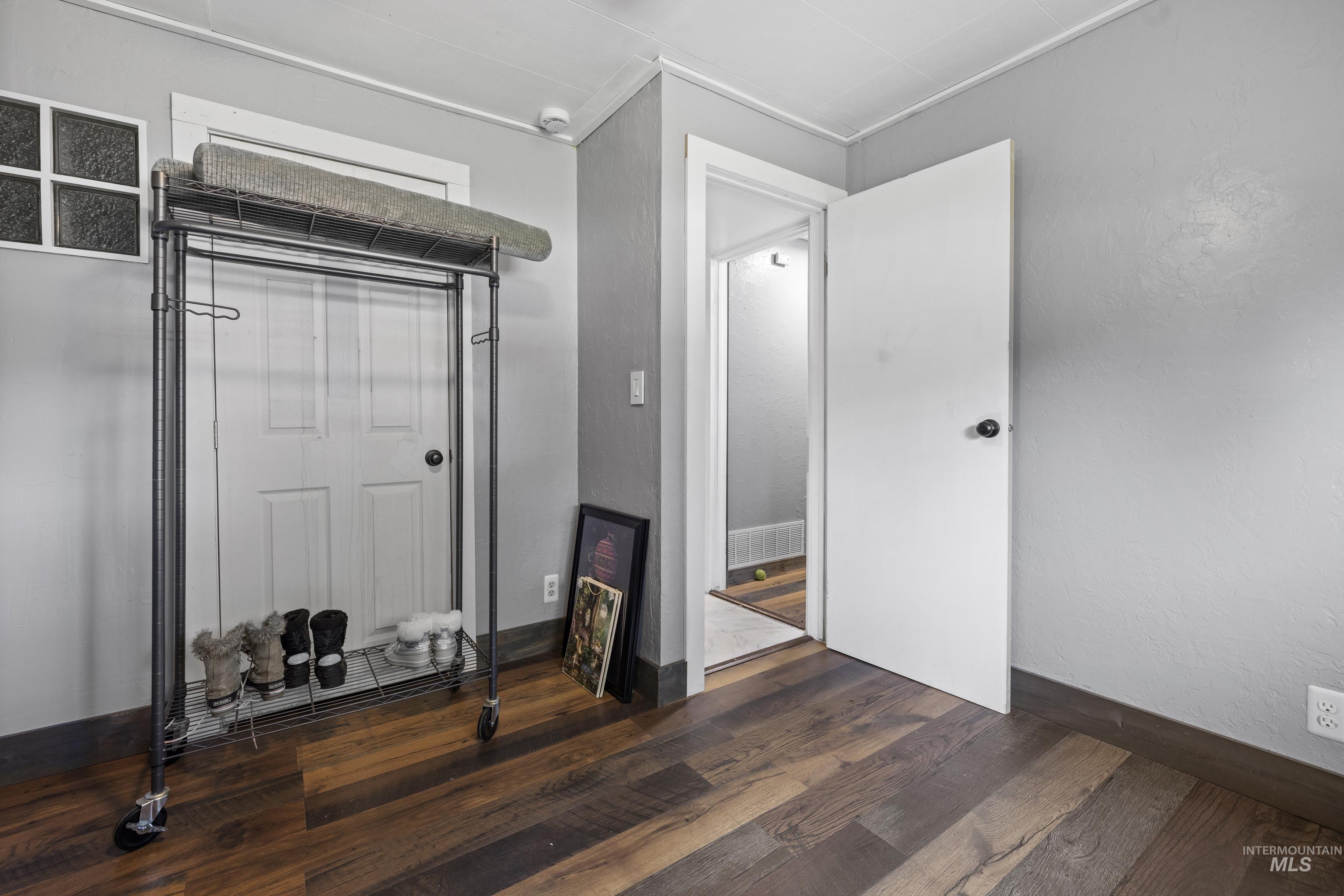 Unfurnished bedroom with wood finished floors and baseboards