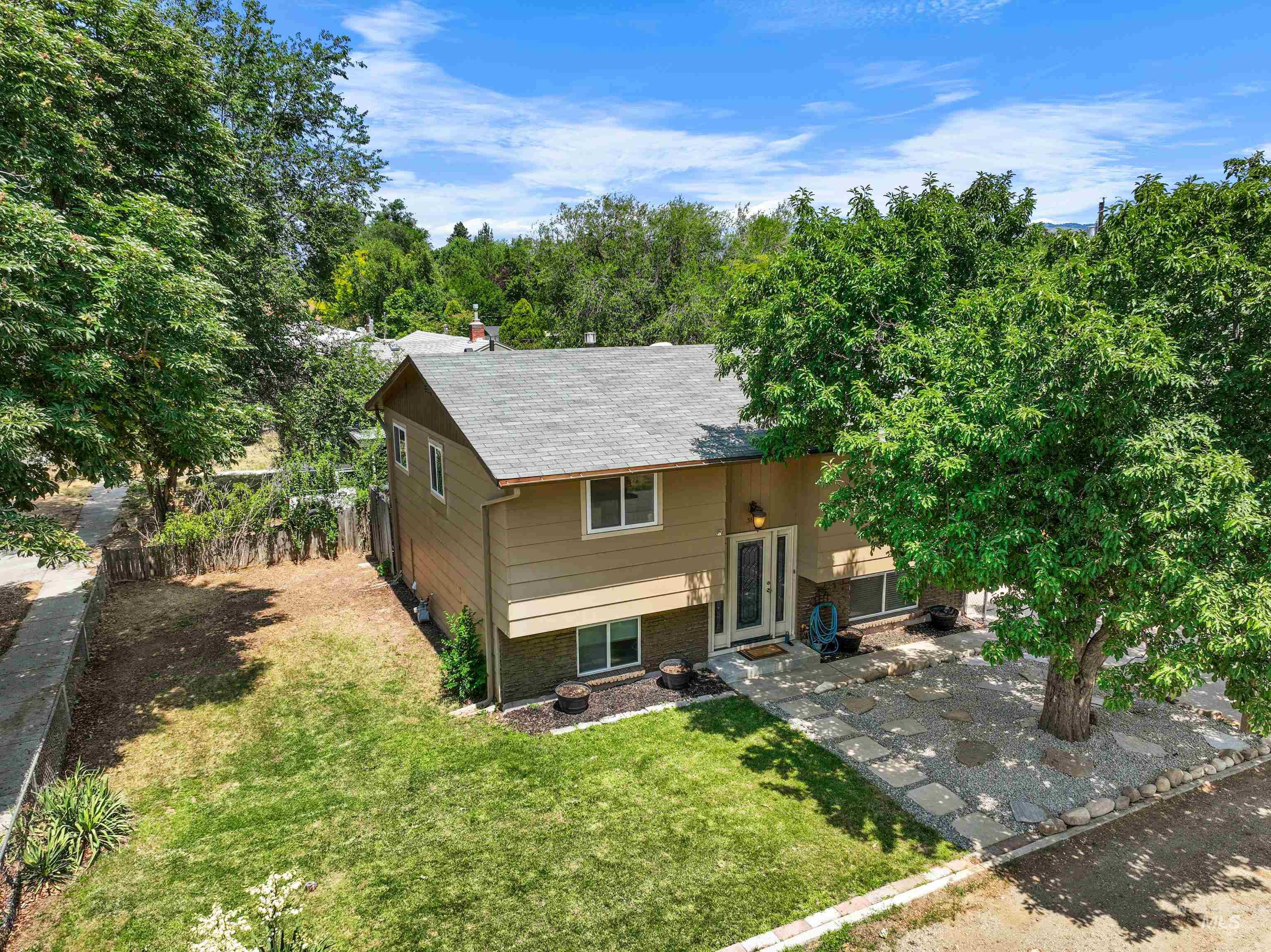 Back of property with a yard and a shingled roof