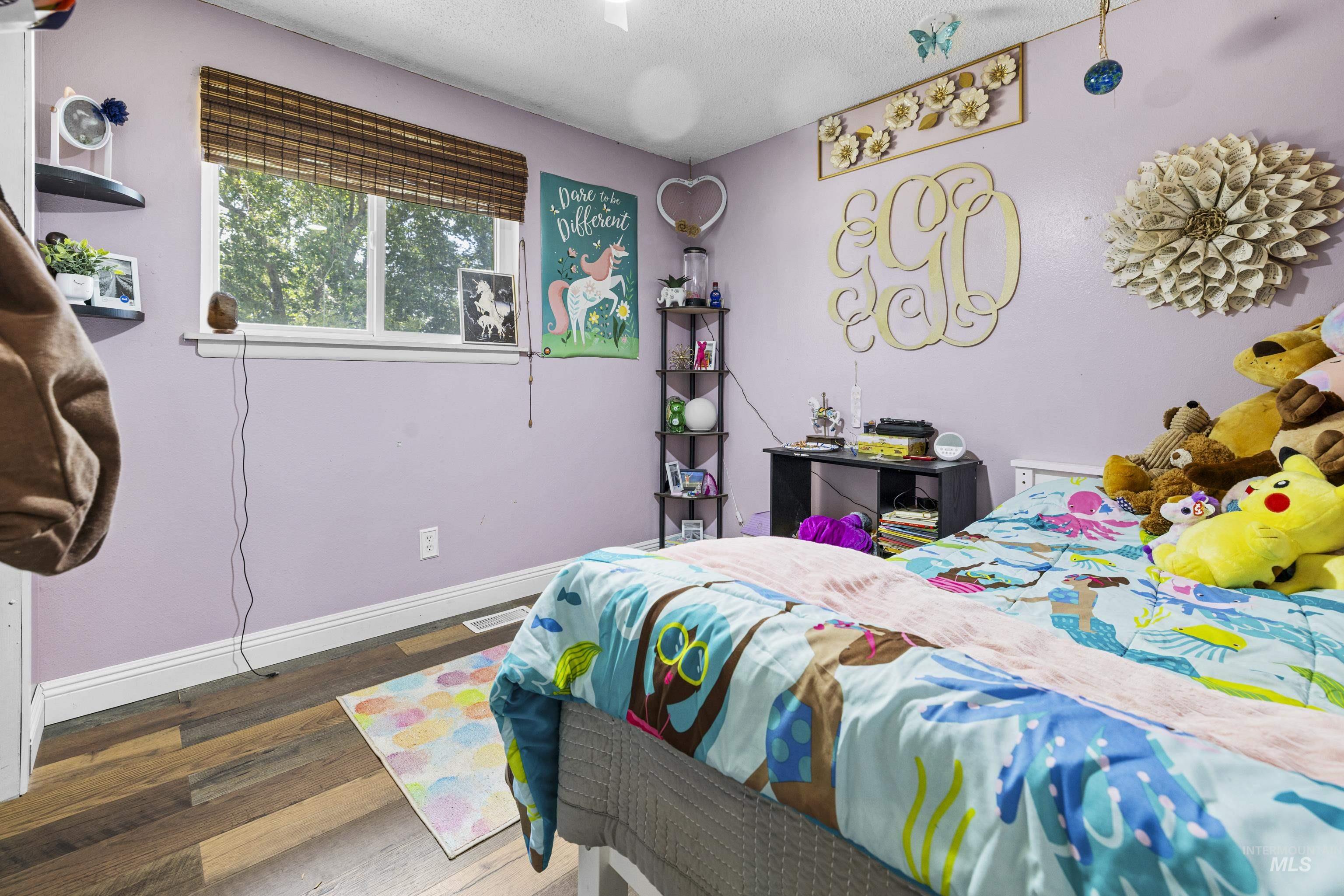 Bedroom with wood finished floors and a textured ceiling
