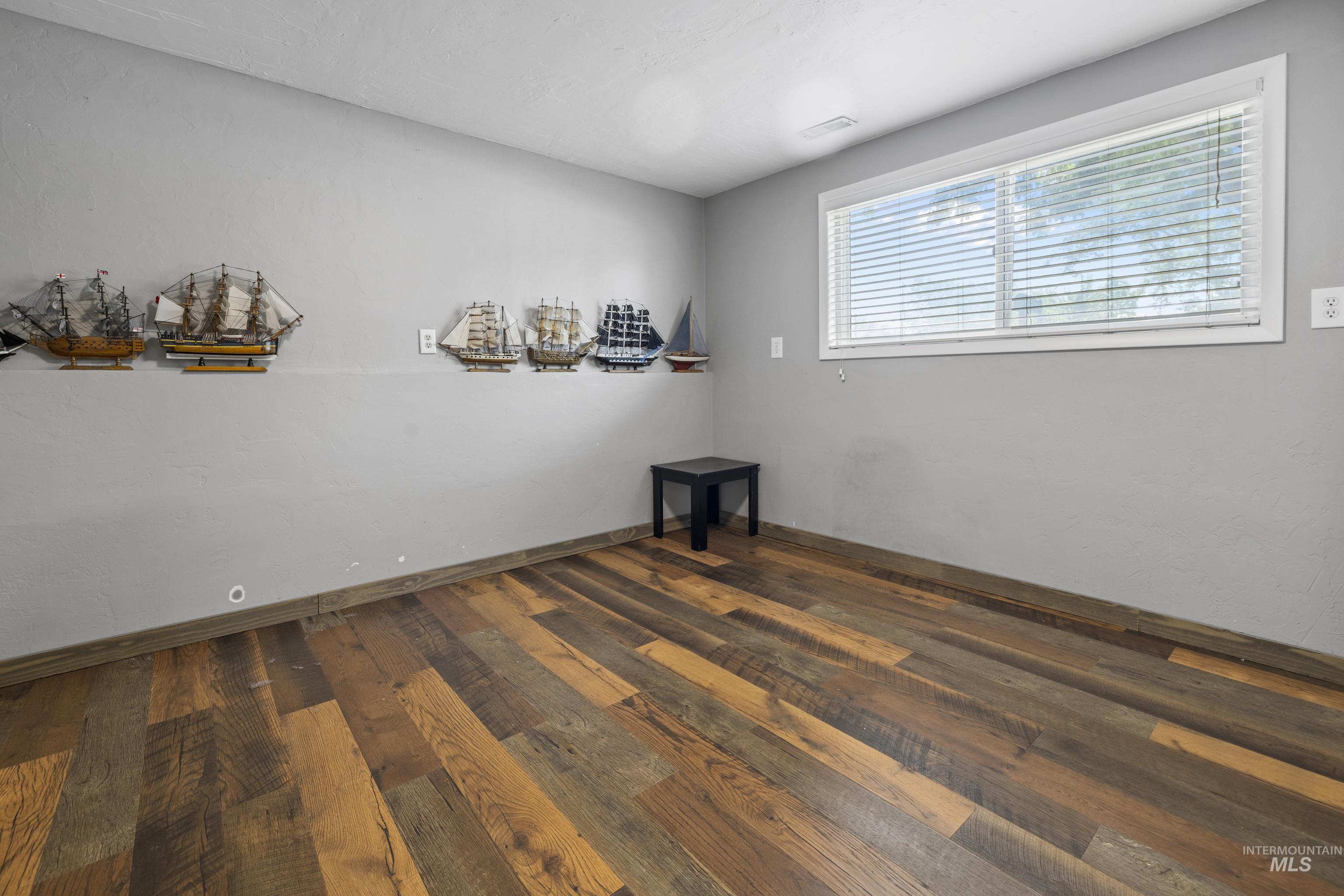 Empty room with dark wood-style floors and baseboards