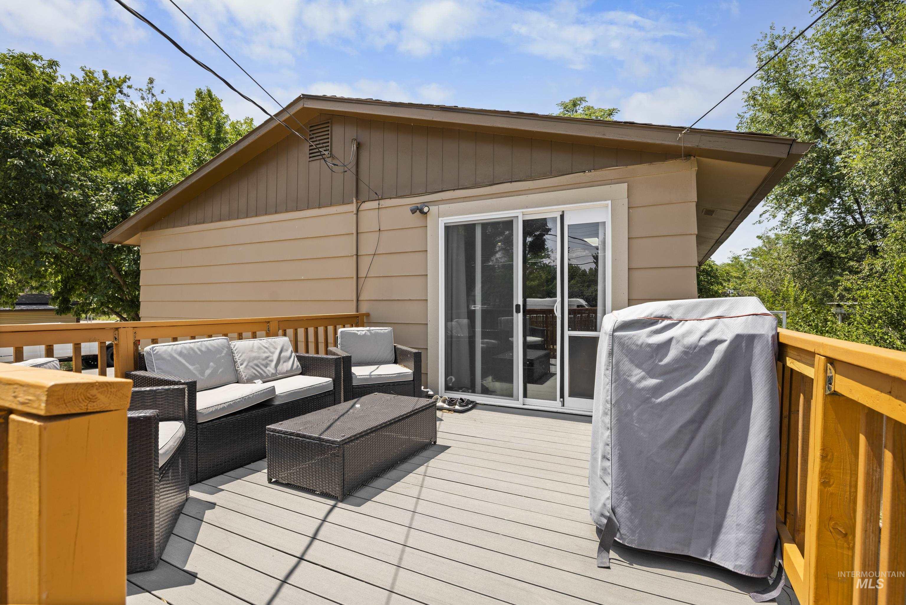 Wooden terrace with an outdoor hangout area and grilling area