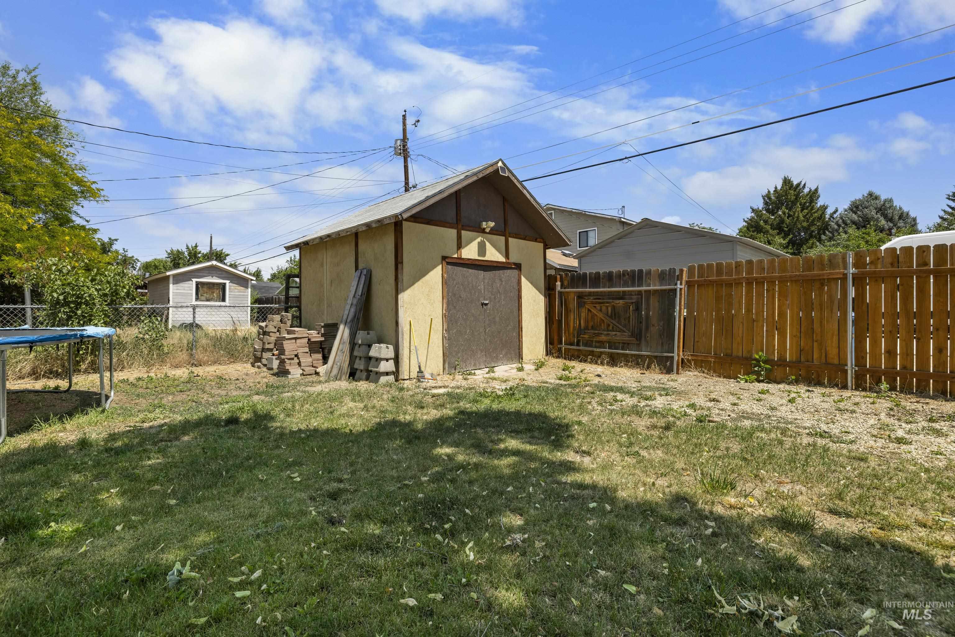 View of shed with a fenced backyard and a trampoline