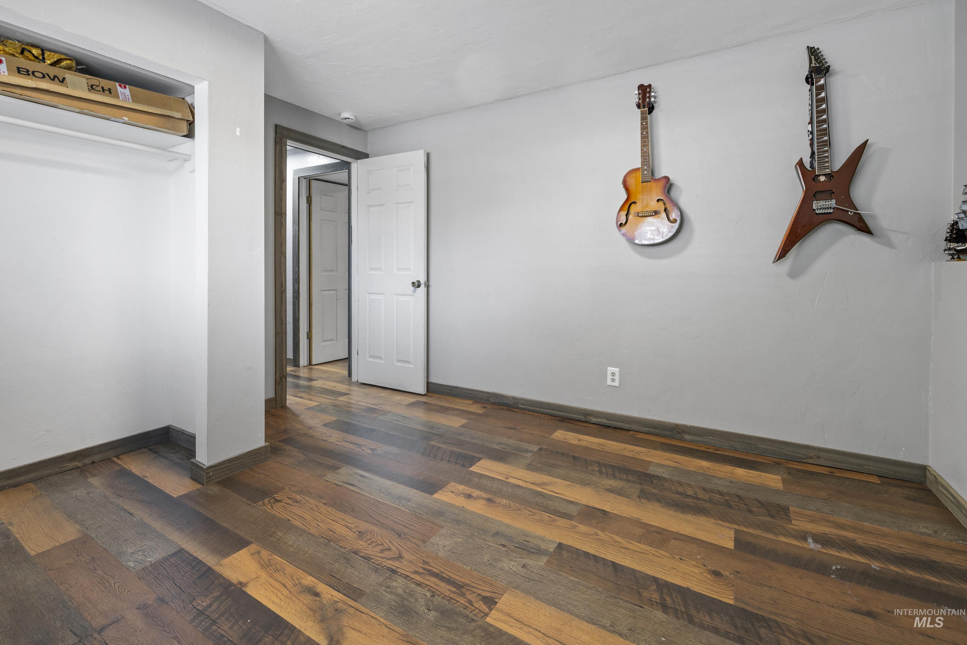 Unfurnished bedroom with dark wood-style floors