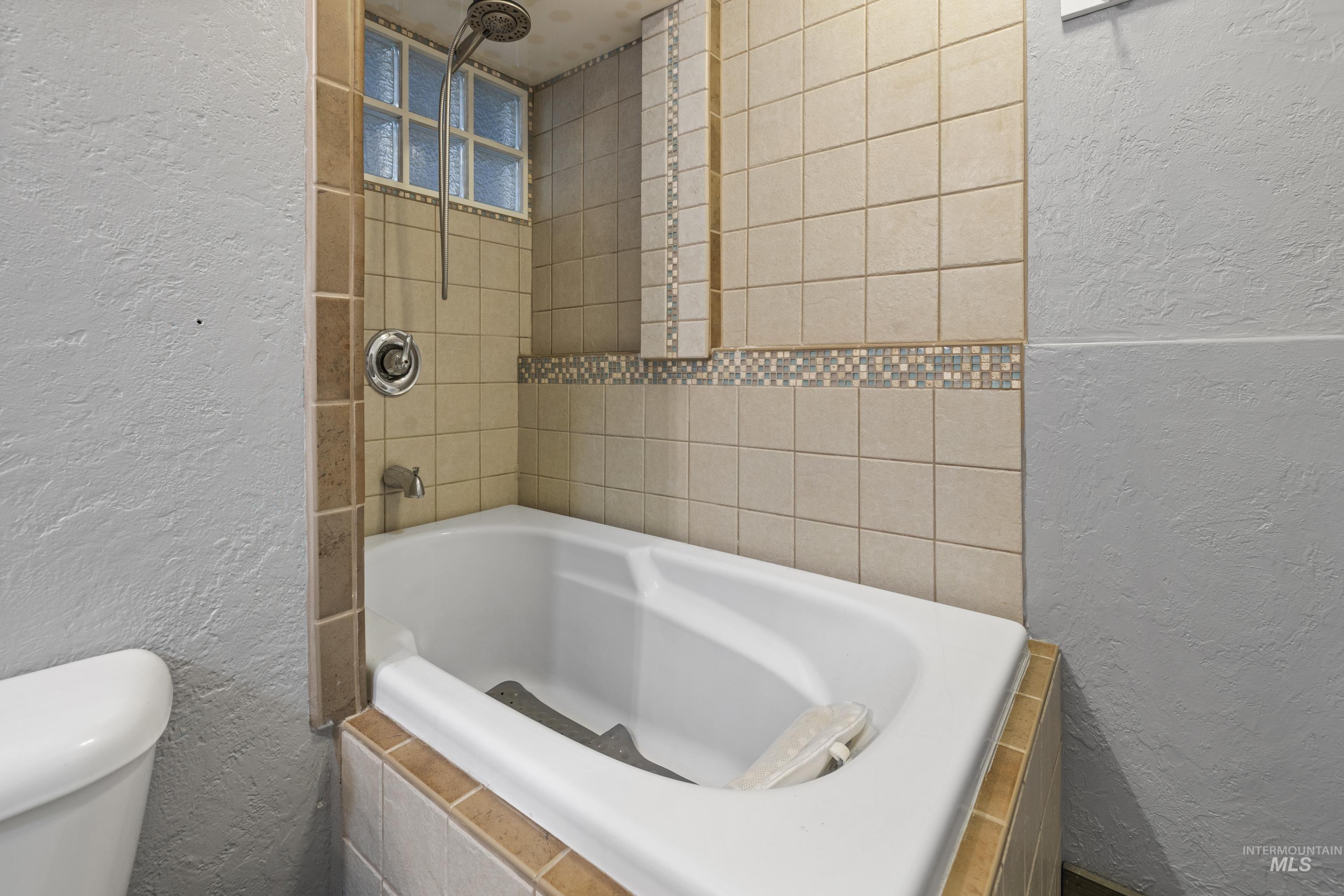 Full bathroom featuring a textured wall