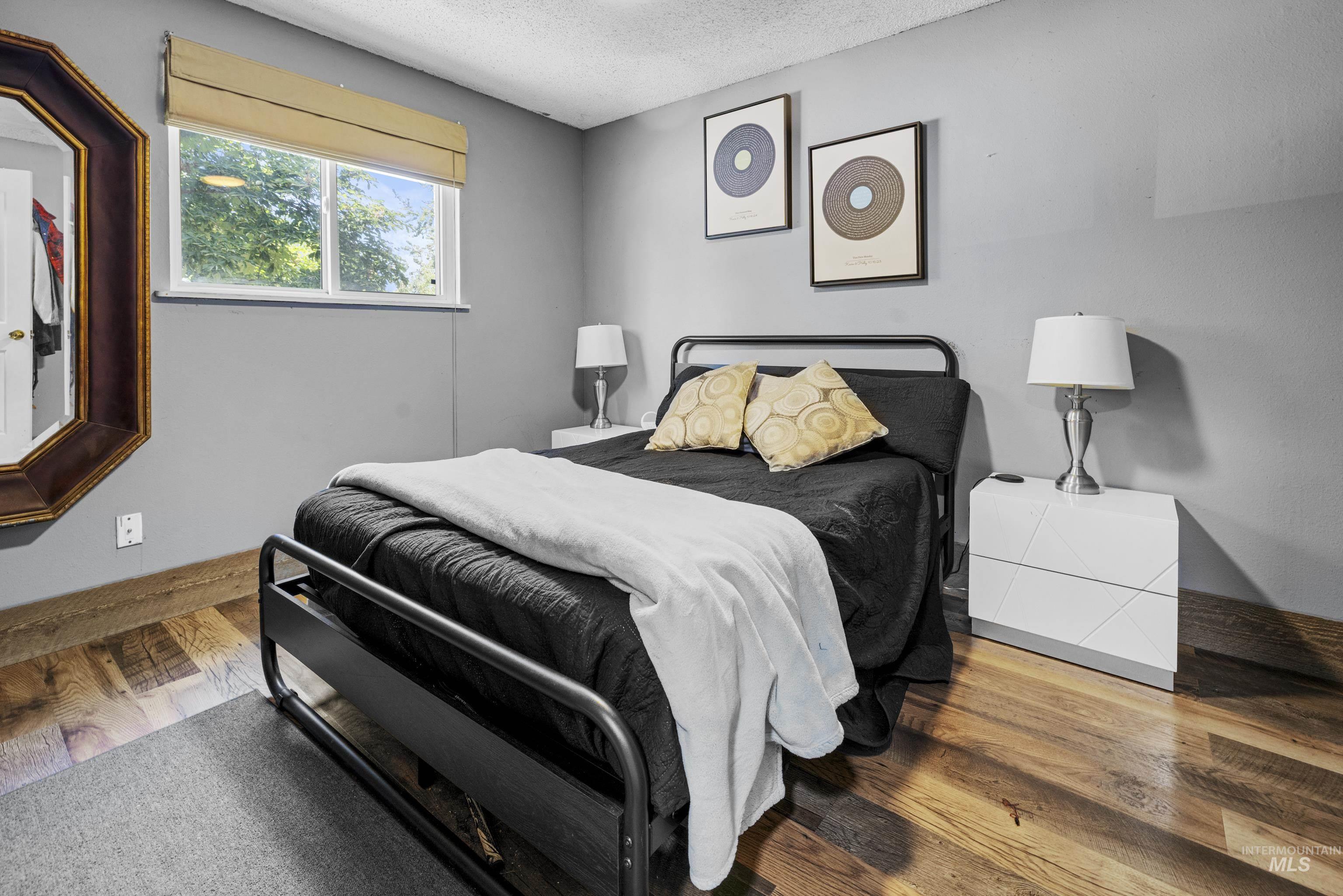 Bedroom featuring a textured ceiling and wood finished floors