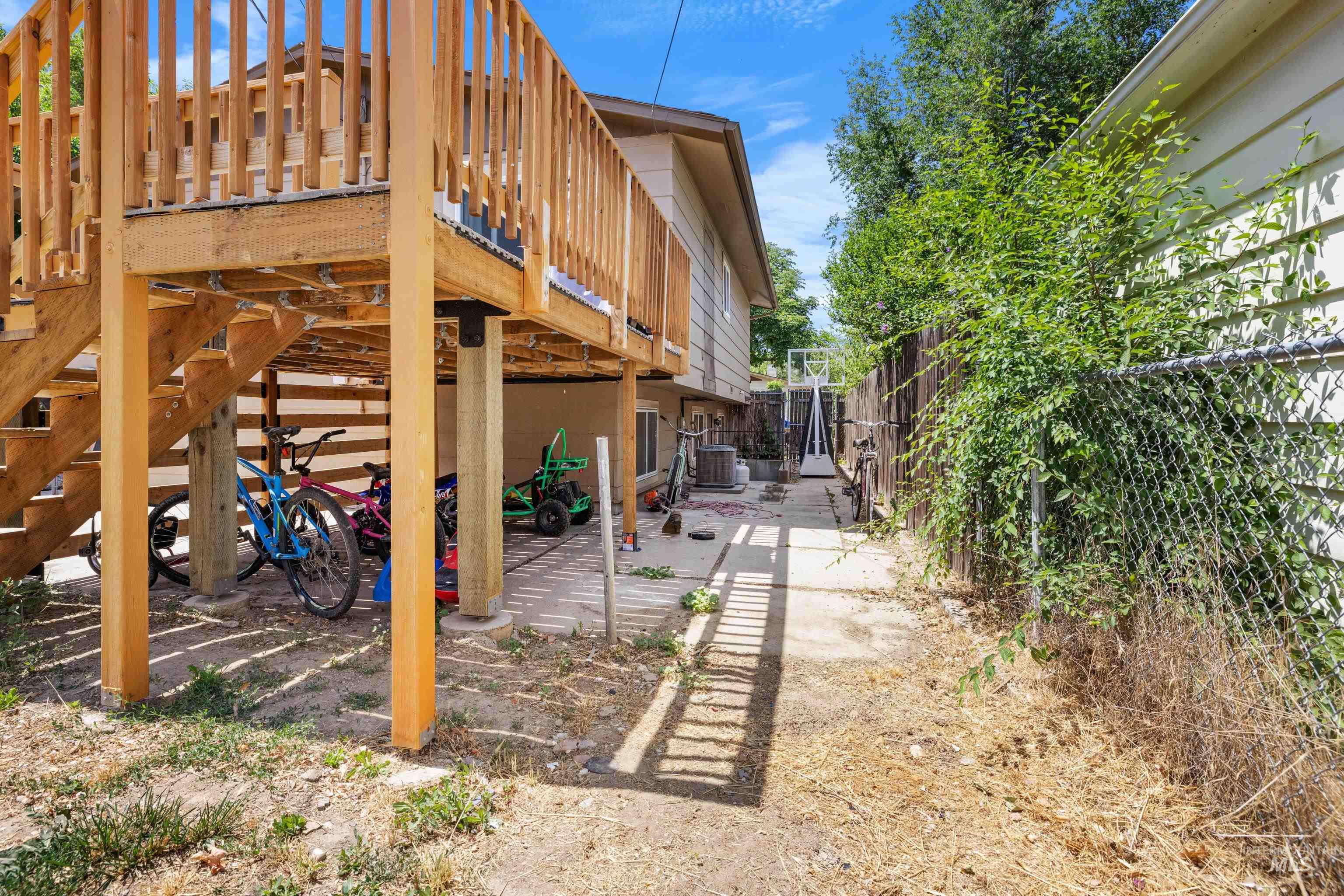 View of property exterior with a wooden deck and a central AC unit