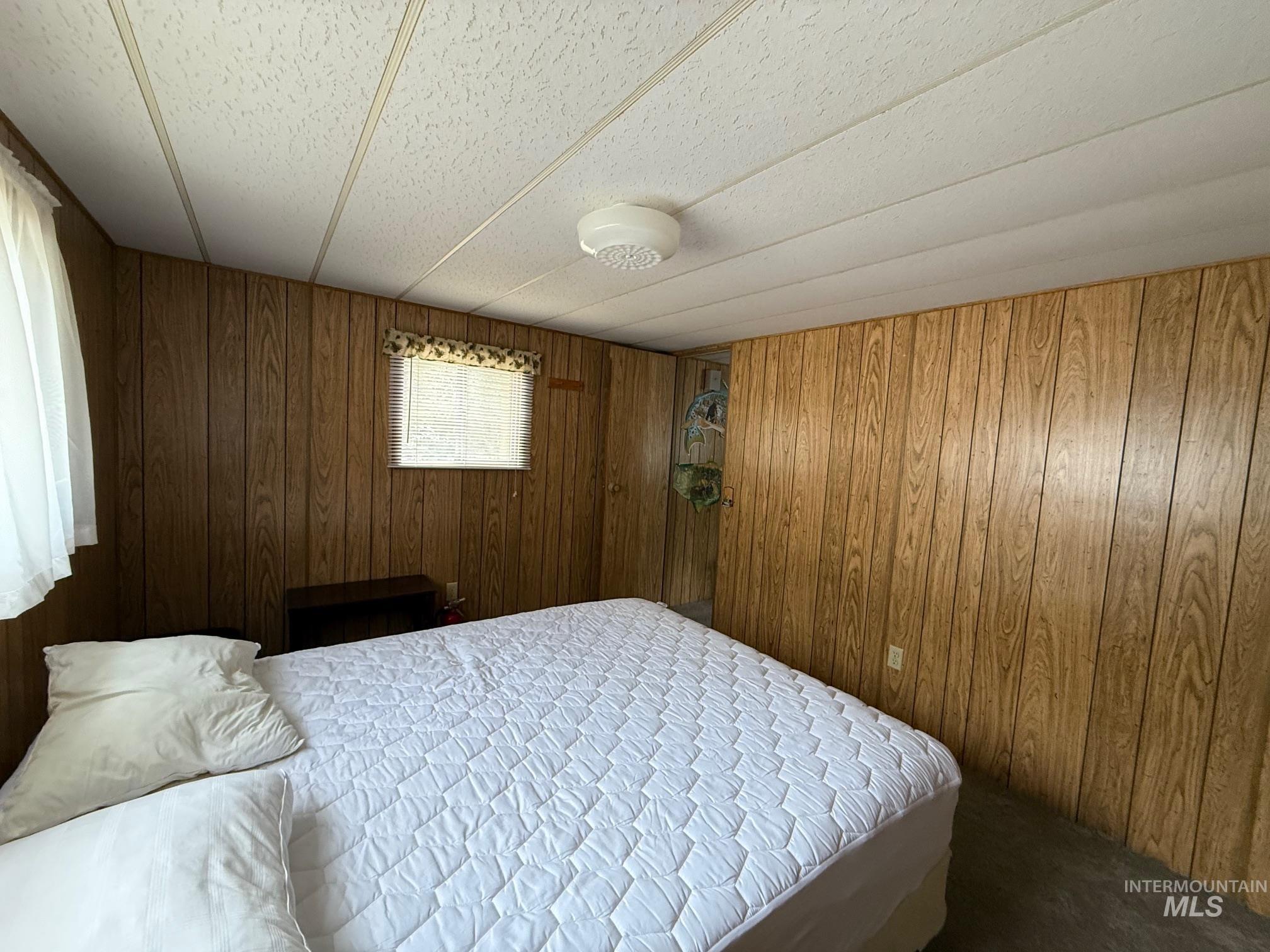 Bedroom with wood walls