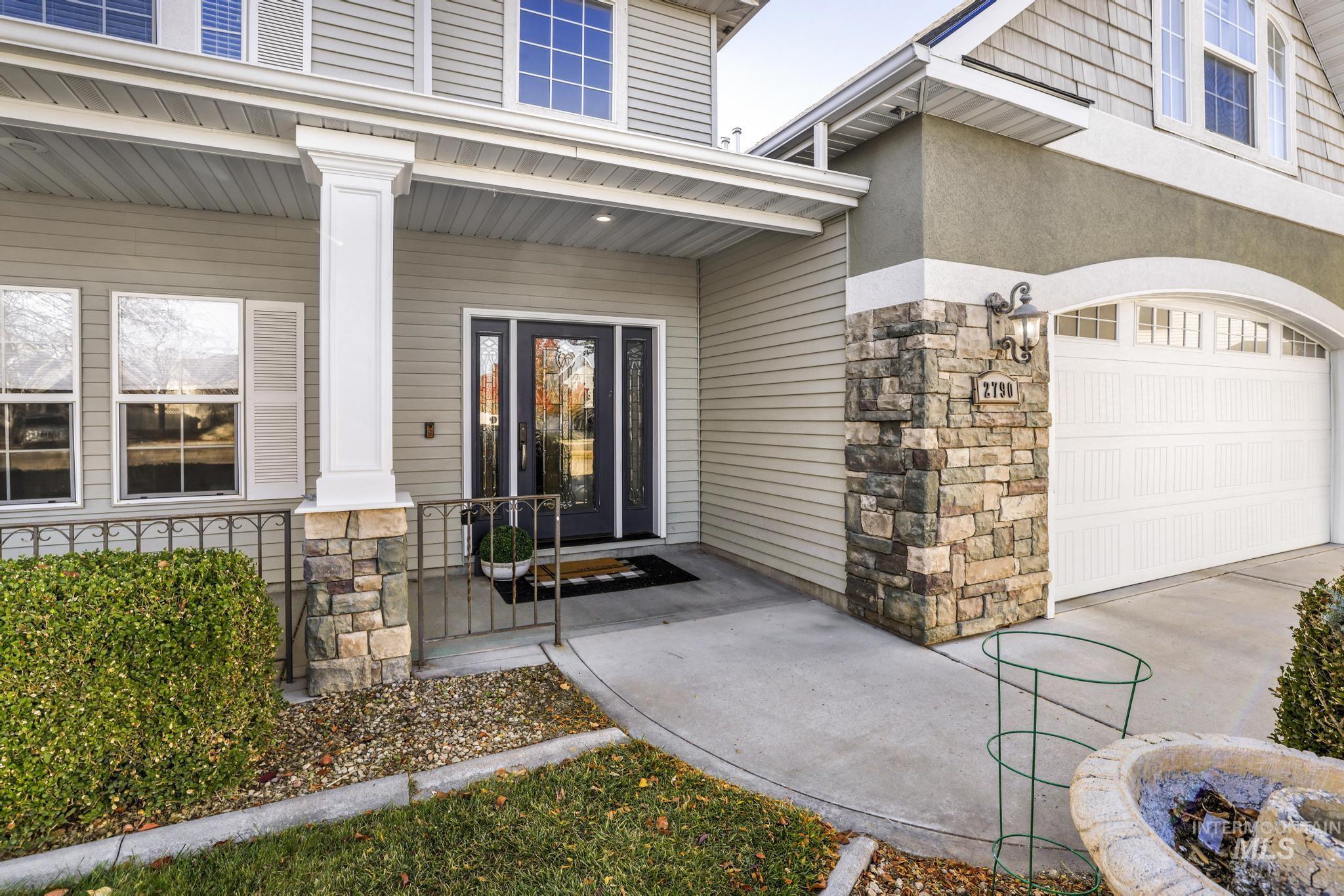 Property entrance with covered porch, stucco and stone siding