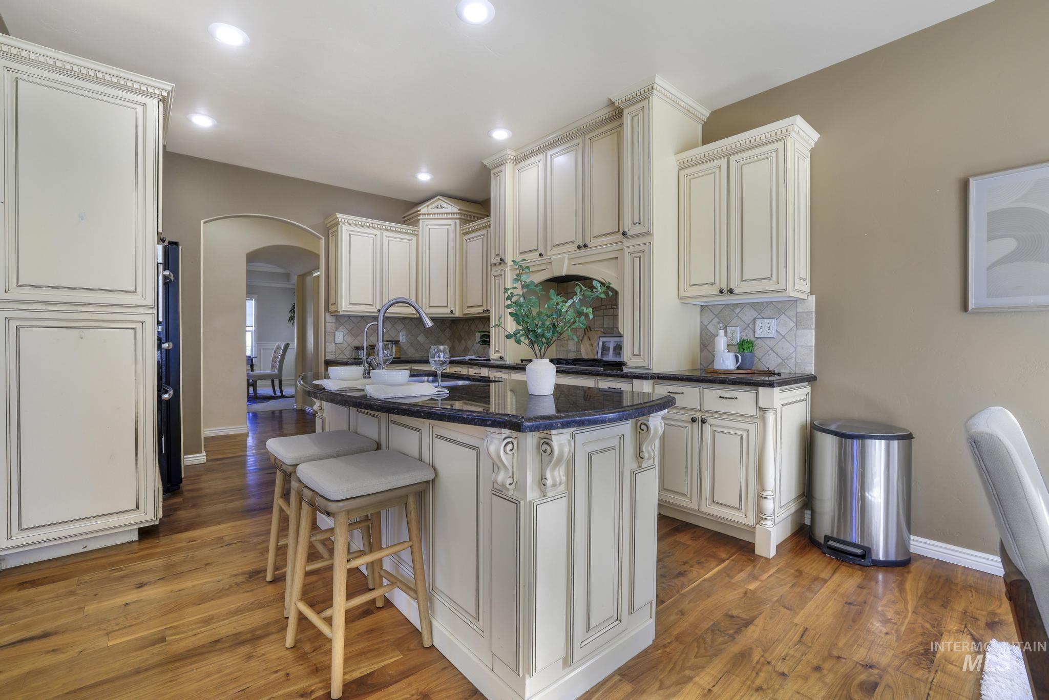 Kitchen with arched walkways, a kitchen bar, a center island with prep sink and recessed lighting