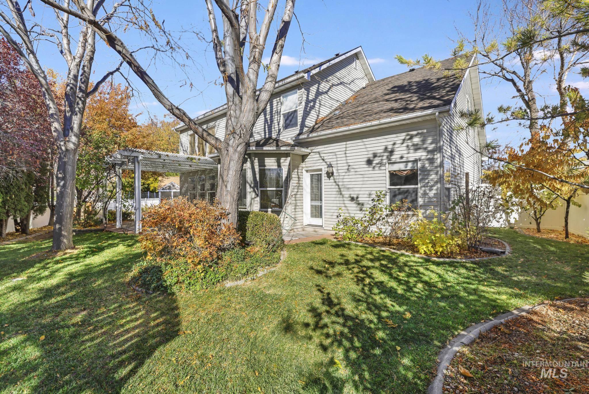 Rear view of property featuring a yard, a patio area, and a pergola