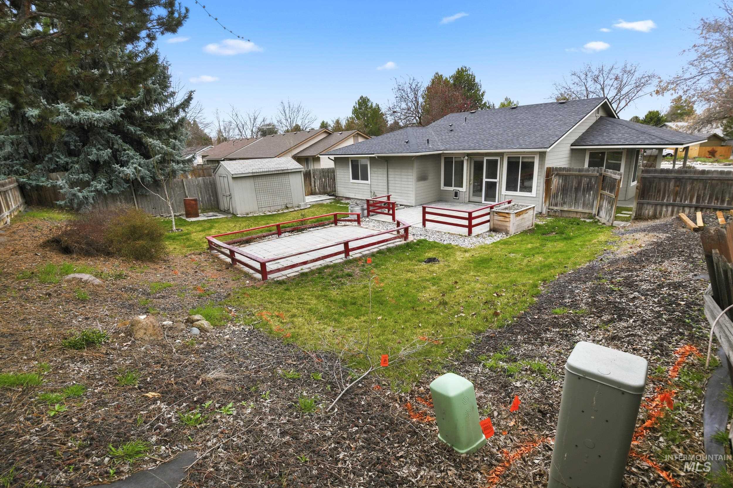 Rear view of property with a fenced backyard, a storage  shed