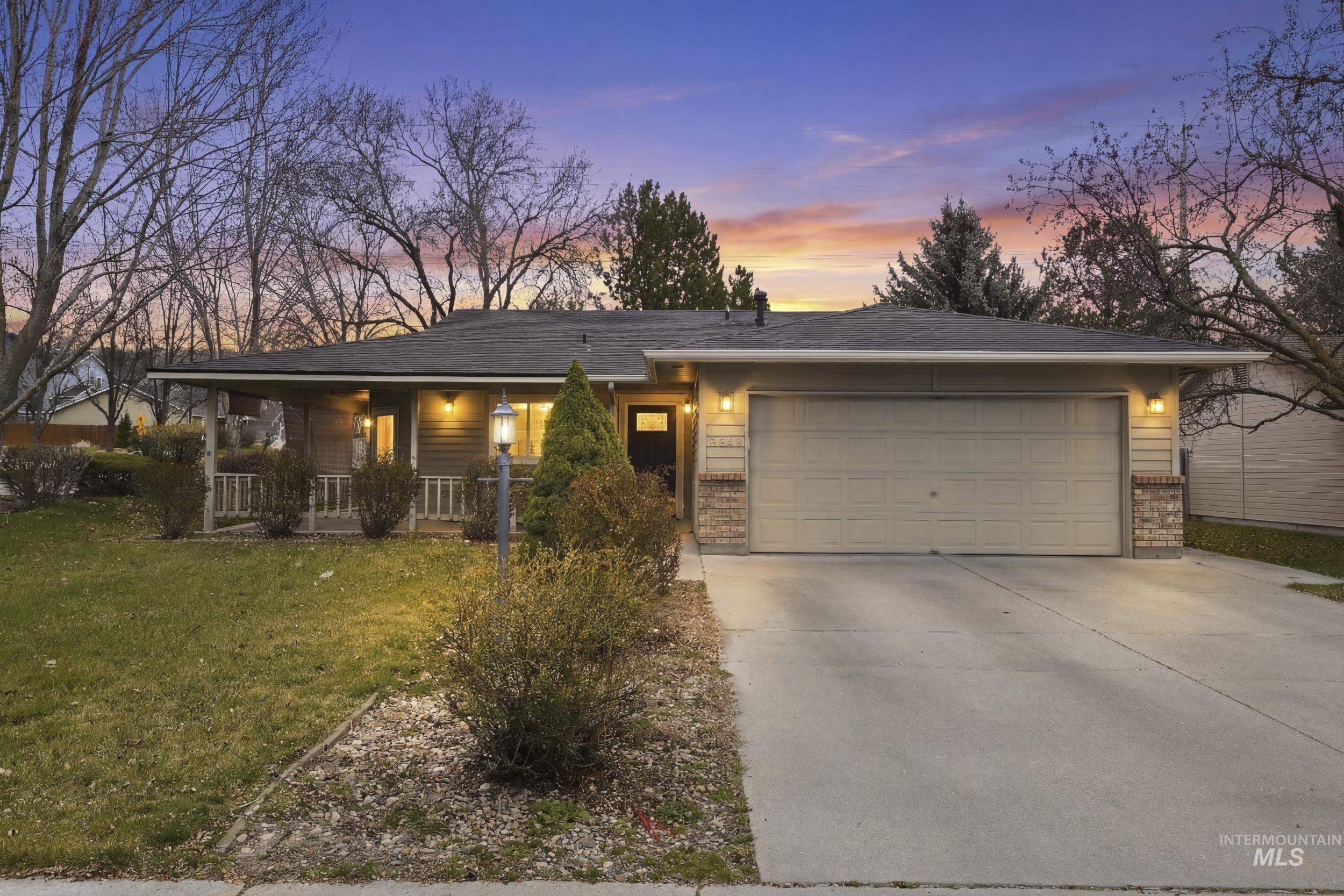 Ranch-style house with an attached garage, a yard, concrete driveway, covered porch, and brick siding