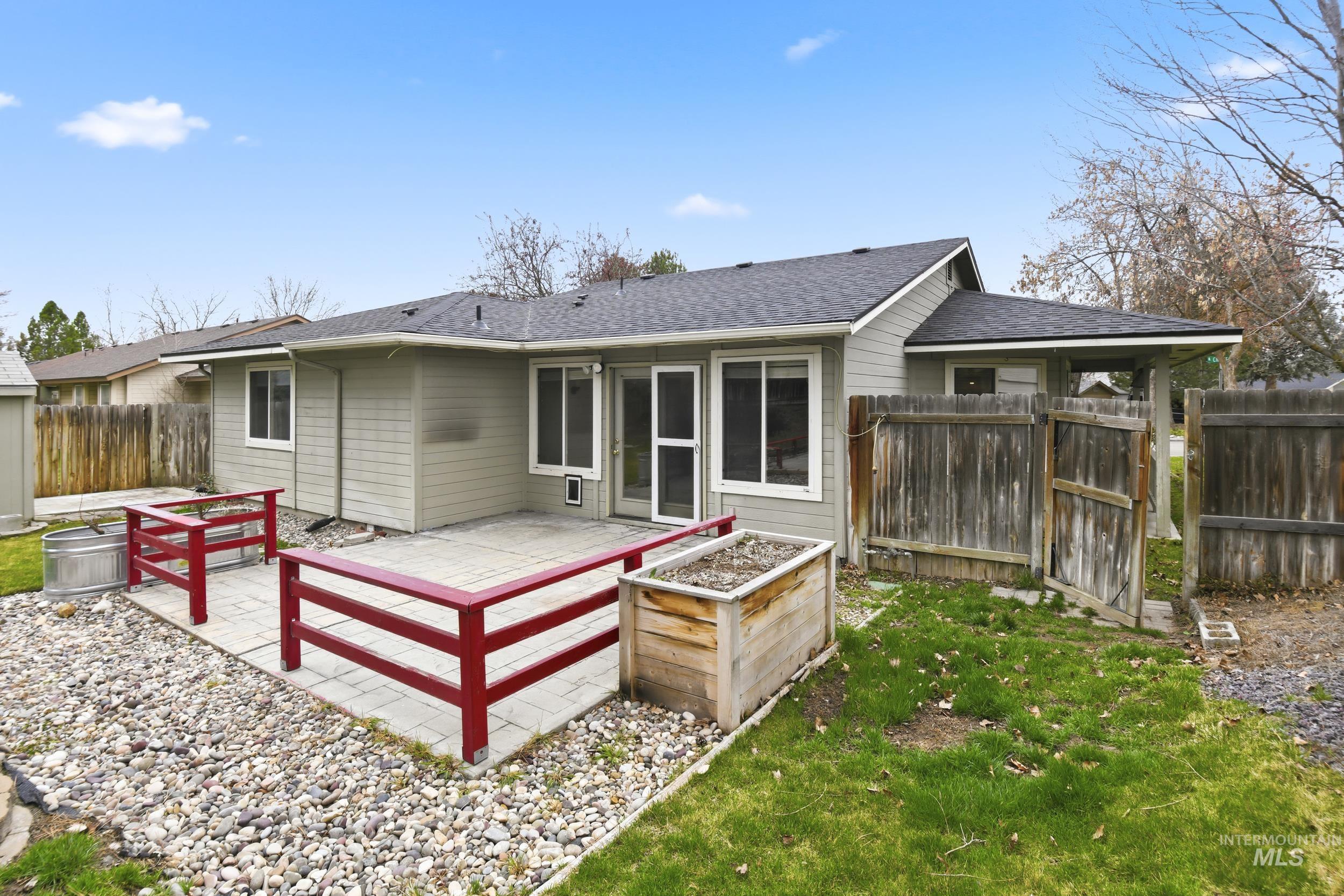 Back of property featuring a garden, a fenced backyard, and a patio