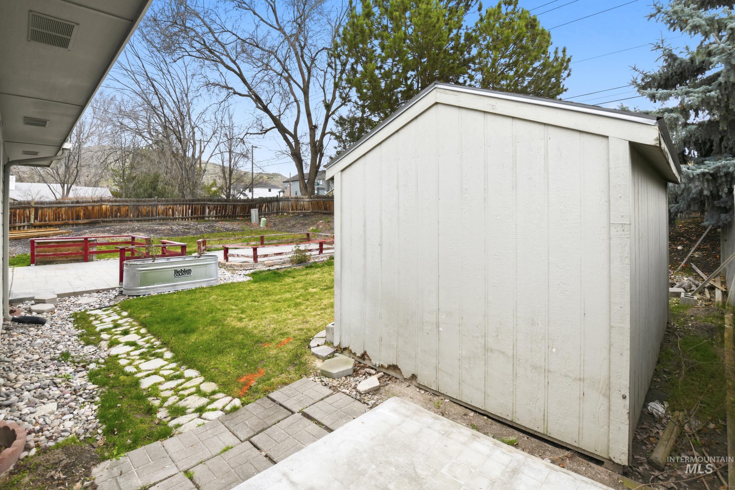 View of shed with a fenced backyard and a garden