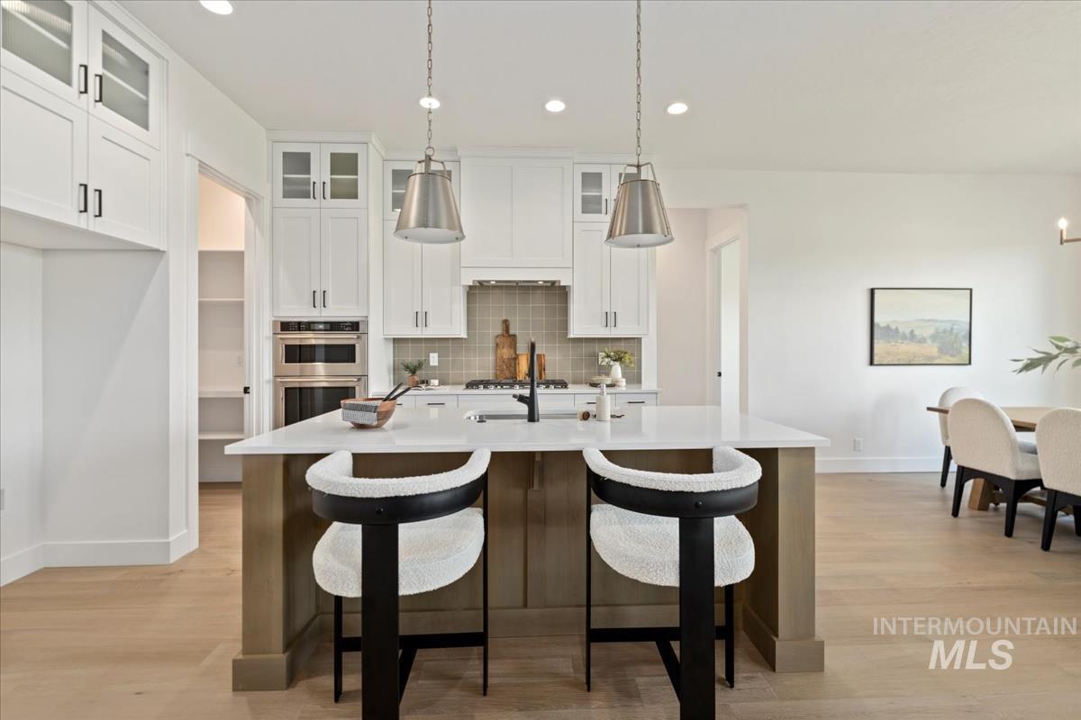 Kitchen island featuring a white countertop, two pendant lights, and integrated seating