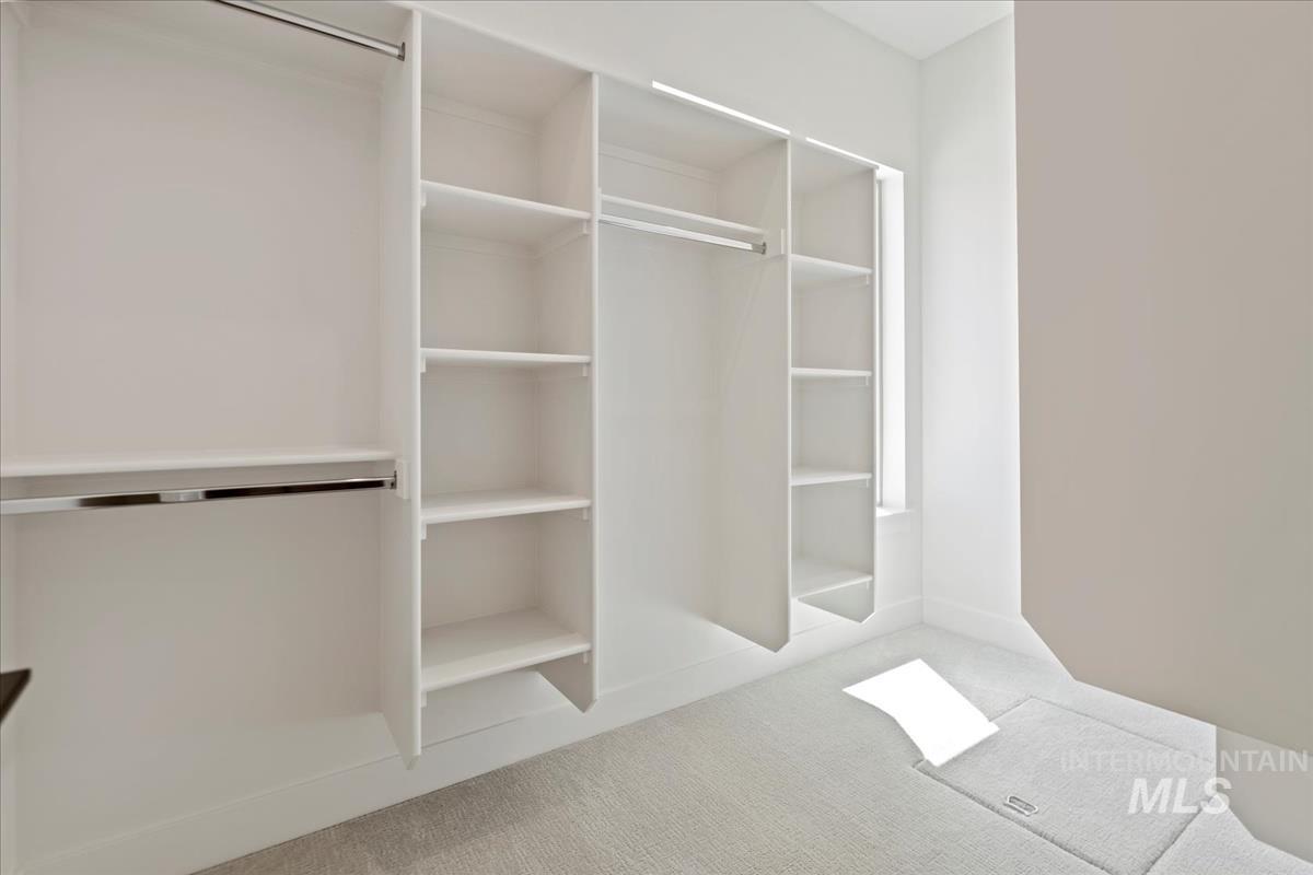 Custom closet system featuring multiple hanging rods and extensive shelving