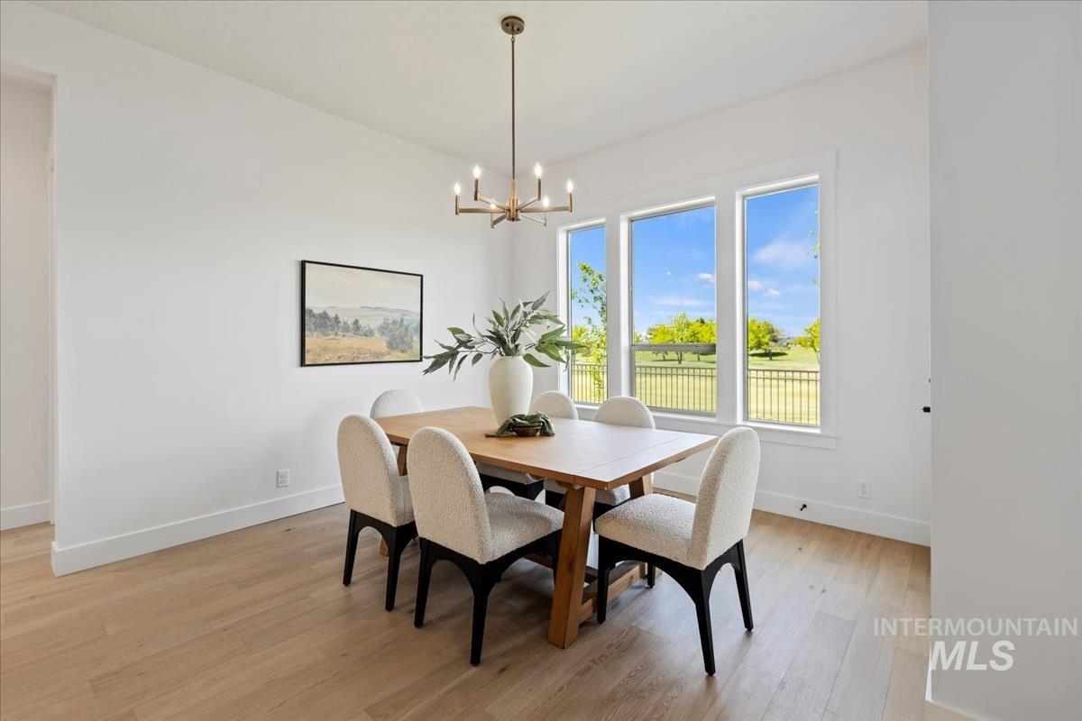 Dining area featuring light wood-finish flooring and a contemporary chandelier