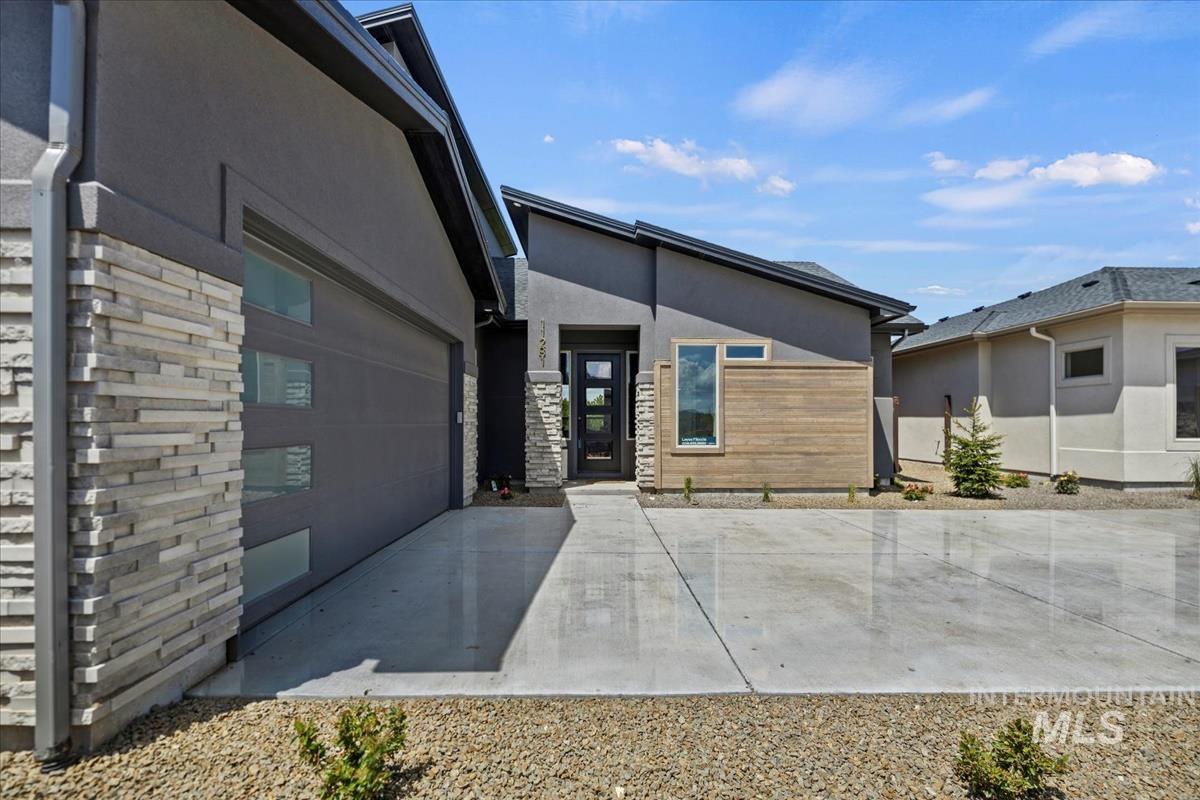 Modern exterior featuring contrasting gray stucco and stacked stone accents