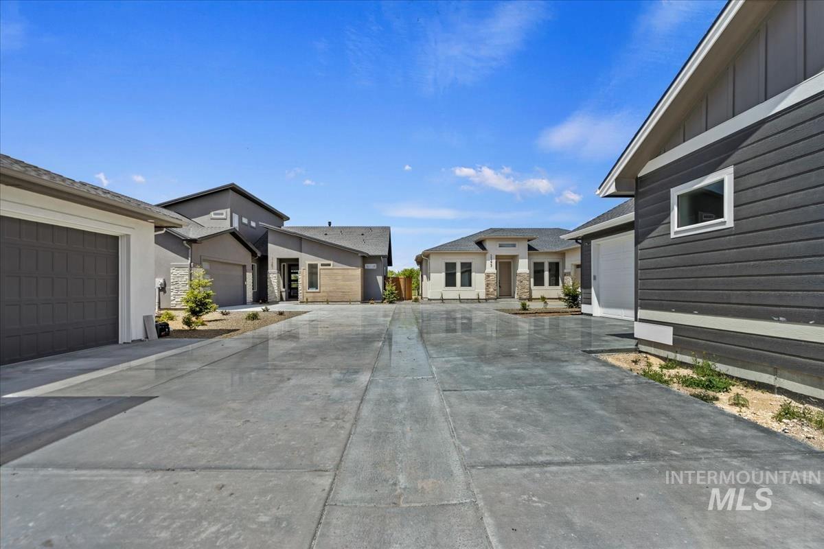 Concrete driveway leading to multiple residences with varying architectural styles