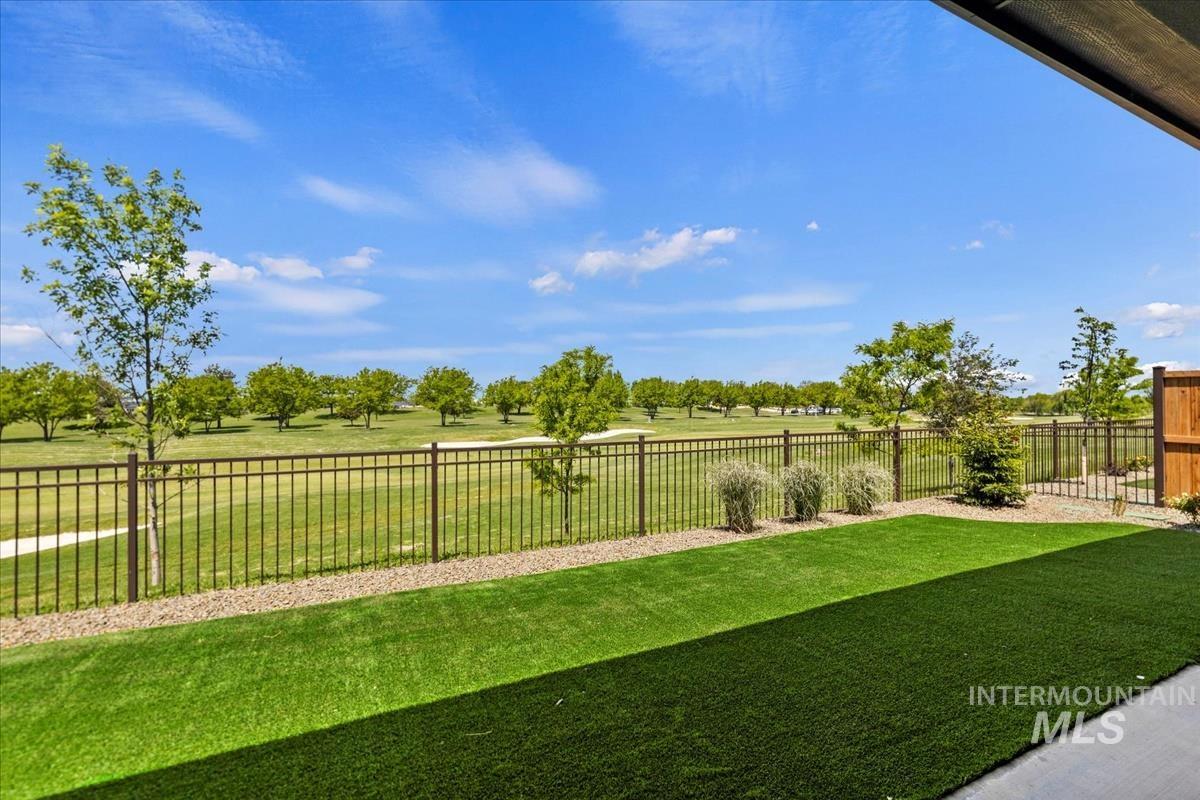 Private patio featuring artificial turf and a metal fence opening to a golf course