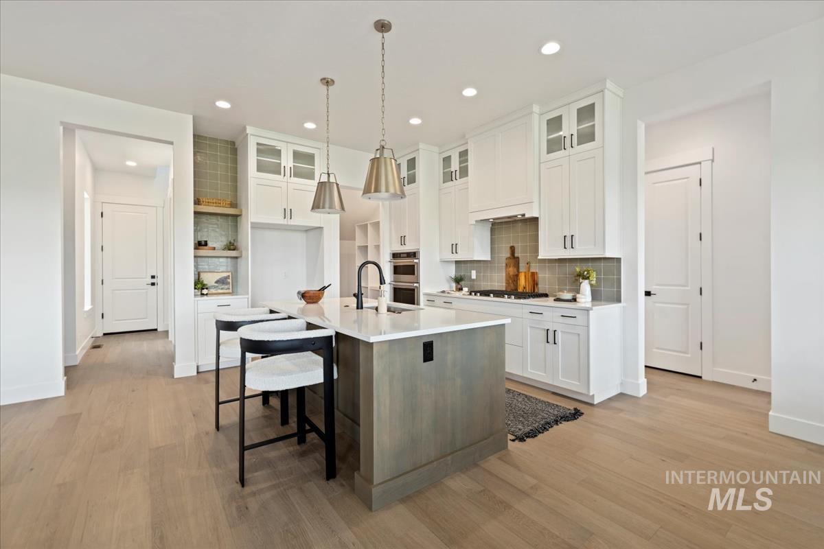 Expansive kitchen featuring a large central island with a light-toned wood-finish base and light-colored countertop