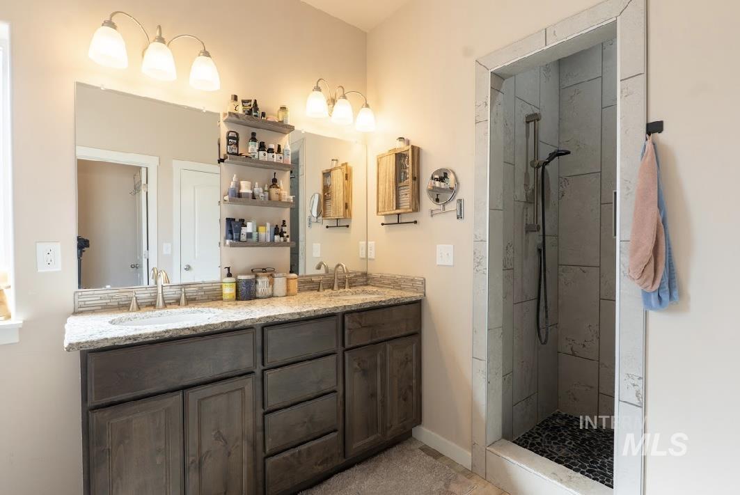 Bathroom with a marble finish shower and double vanity