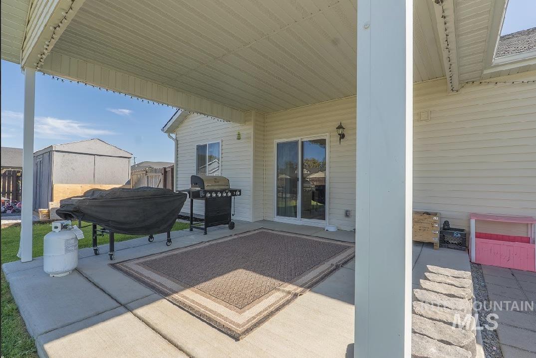 View of patio with a grill