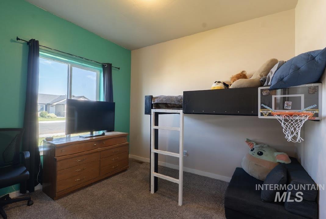Bedroom featuring dark colored carpet and baseboards