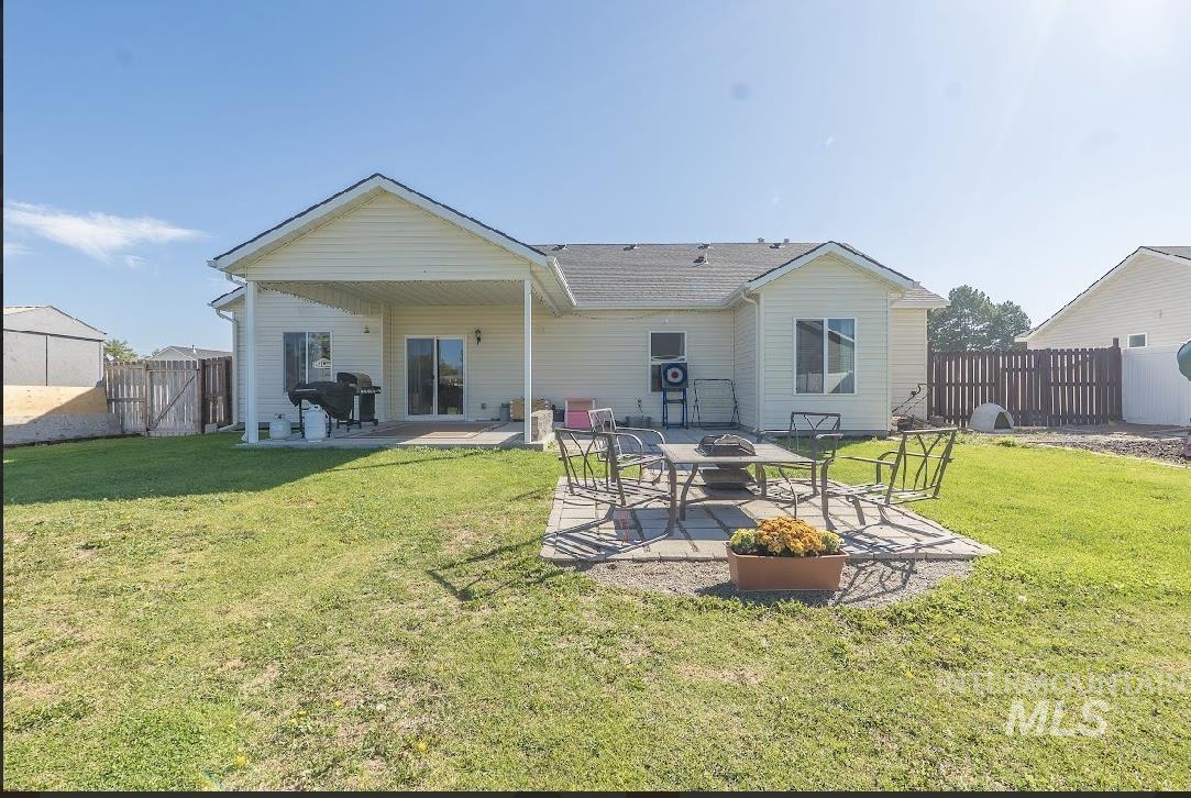 Back of property featuring a patio area, an outdoor fire pit, and a fenced backyard