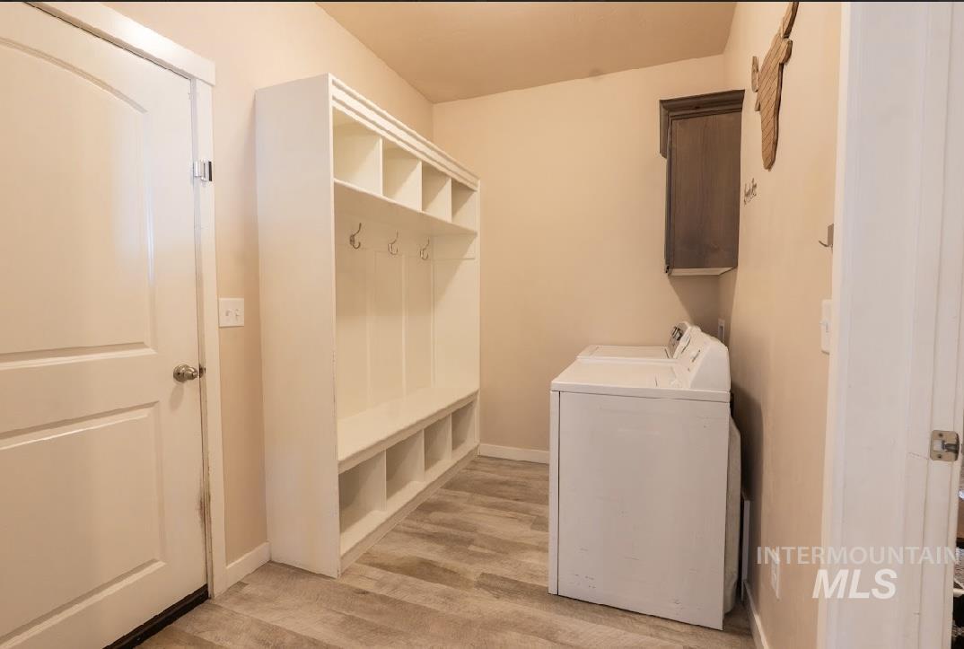 Mudroom featuring washing machine and dryer and light wood finished floors