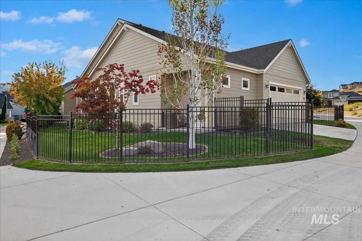 View of front of property featuring driveway, a fenced front yard, and a garage