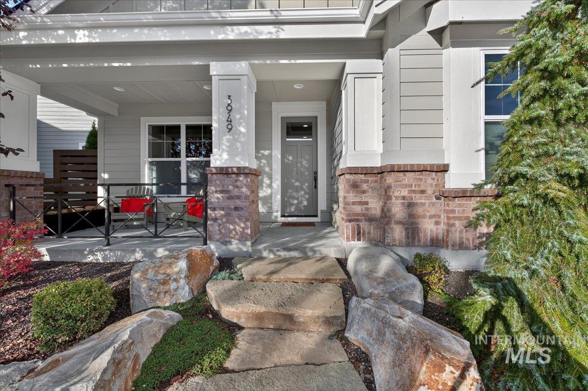 Entrance to property featuring brick siding and covered porch