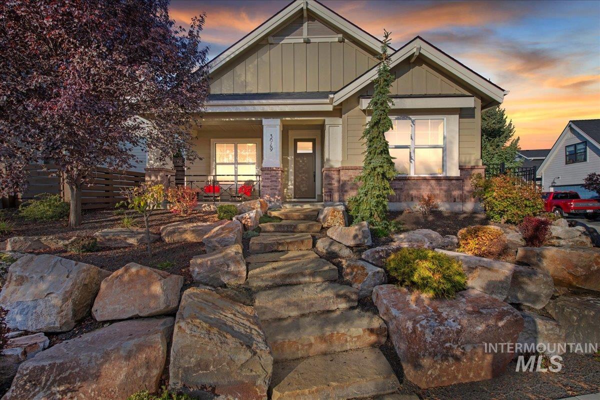 View of front of house with a porch, board and batten siding, and brick siding