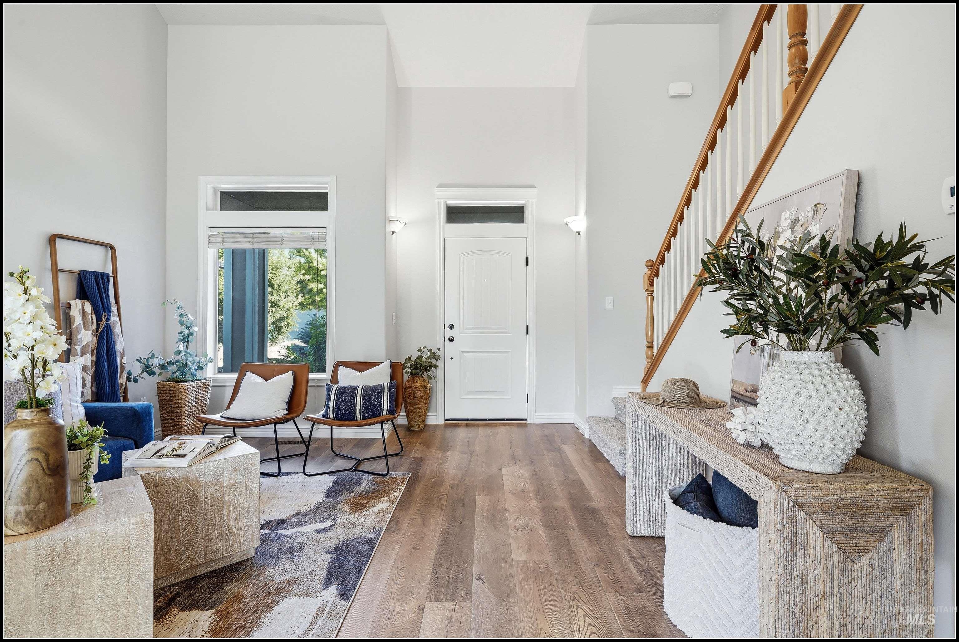 Foyer featuring a contemporary staircase with wood banister, and a white entry door with transom window