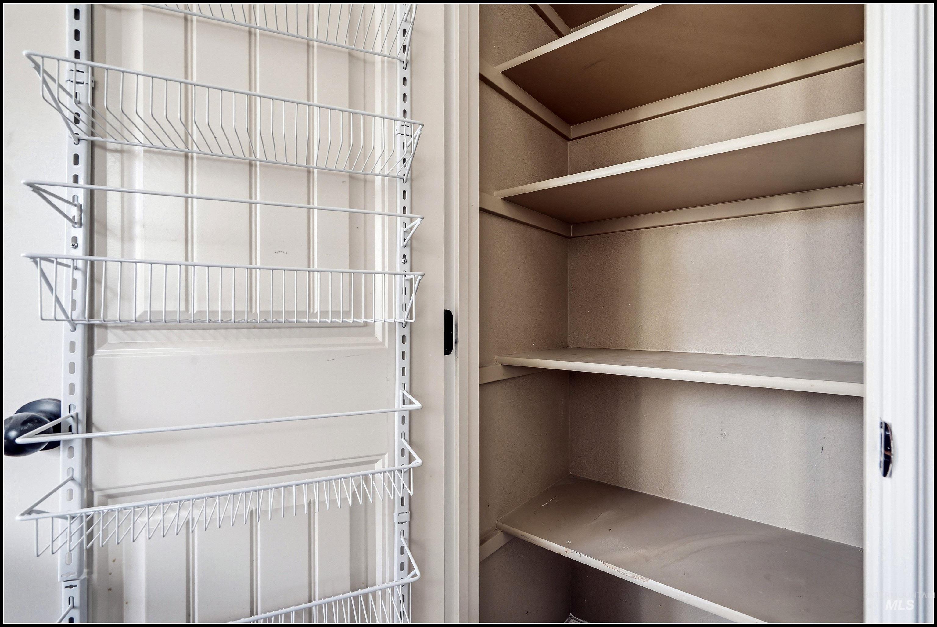 Pantry storage featuring built-in shelving and an over-the-door wire rack system