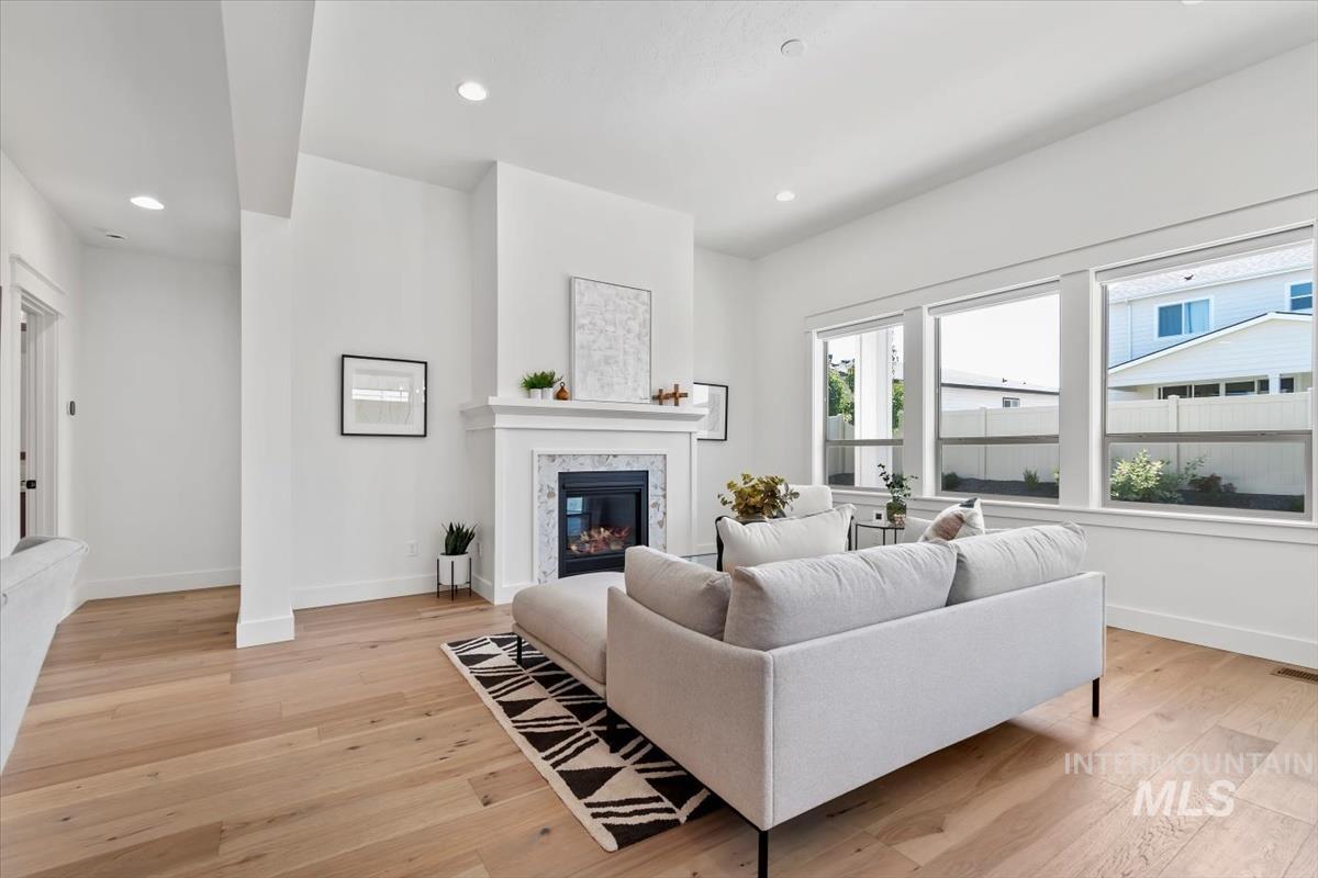 Living room featuring a fireplace, light wood-style flooring, and recessed lighting