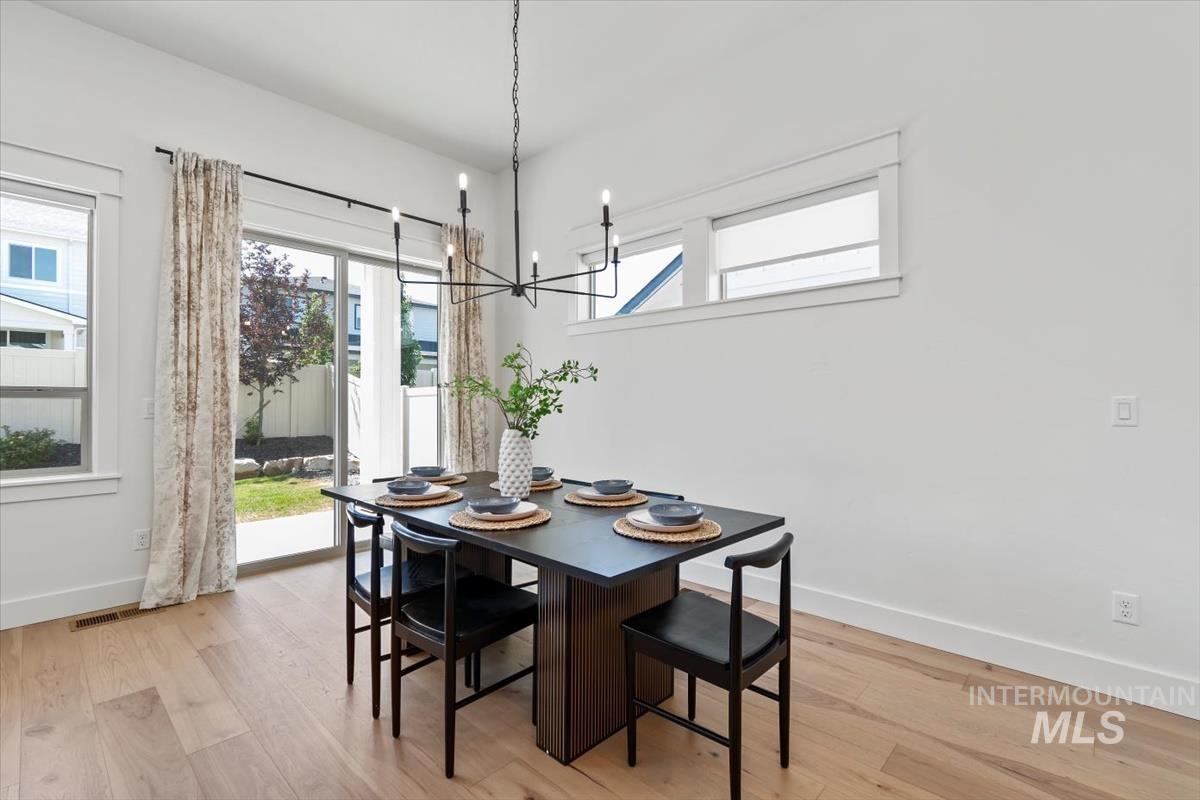 Dining room featuring light wood-style flooring and a chandelier
