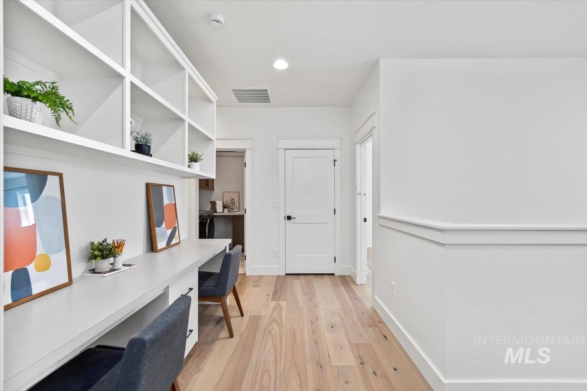 Office featuring built in desk, light wood-style floors, and recessed lighting