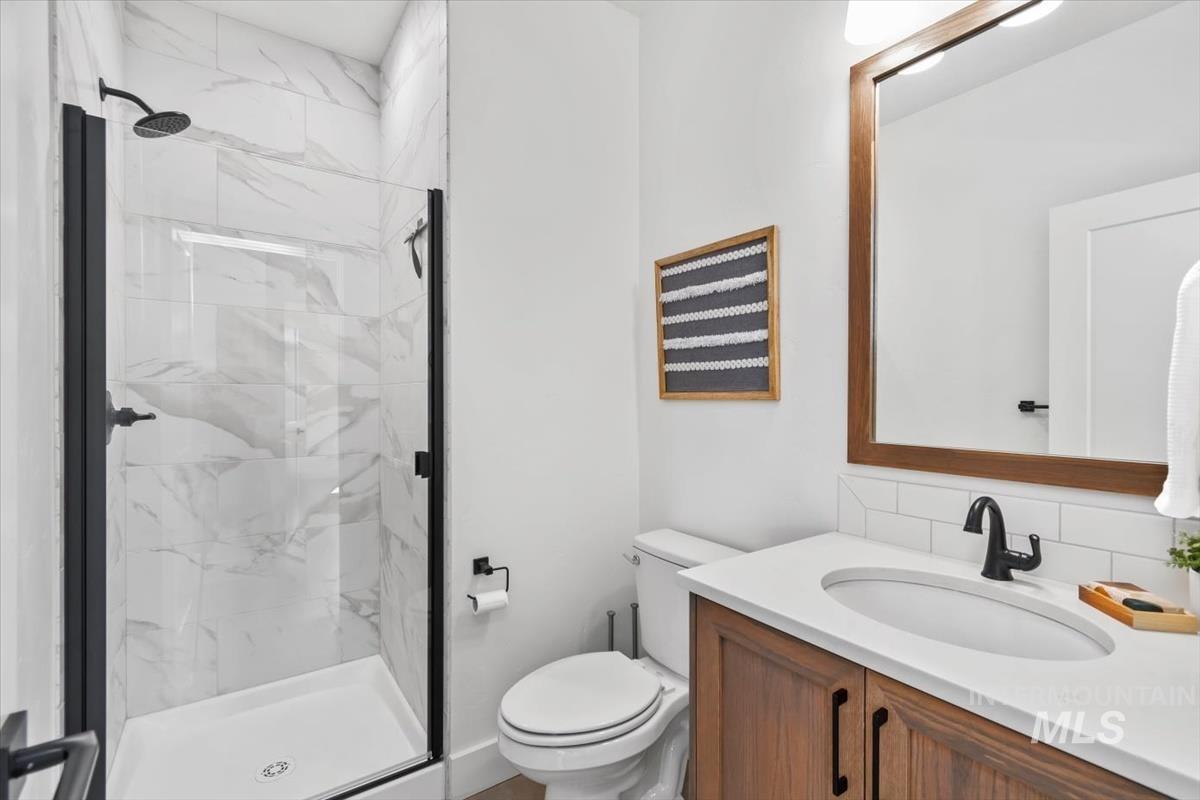 Full bath with a marble finish shower and vanity
