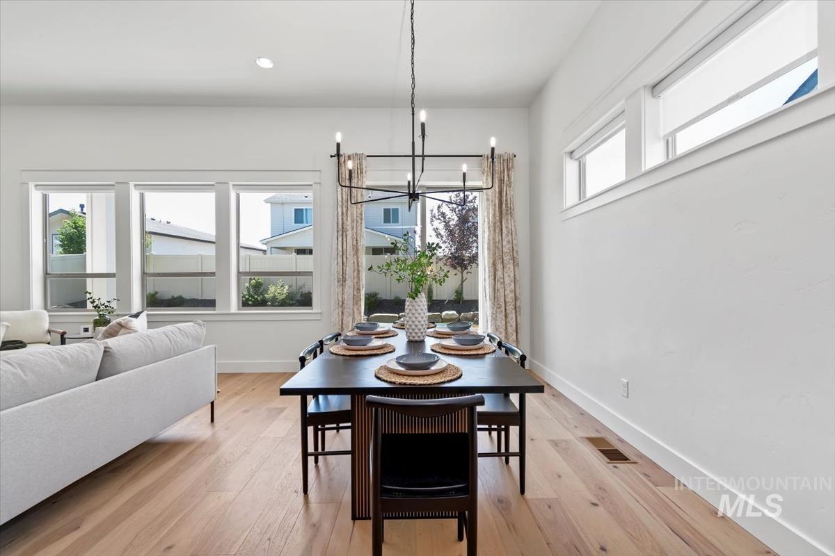 Dining area with a chandelier, light wood finished floors, and recessed lighting