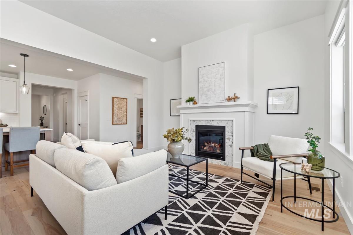 Living room featuring light wood-type flooring, a fireplace, and recessed lighting