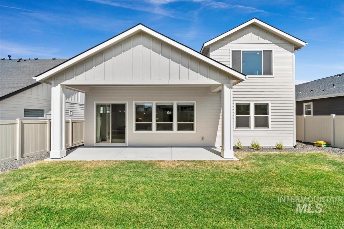 Back of property featuring board and batten siding, a patio area, and a fenced backyard