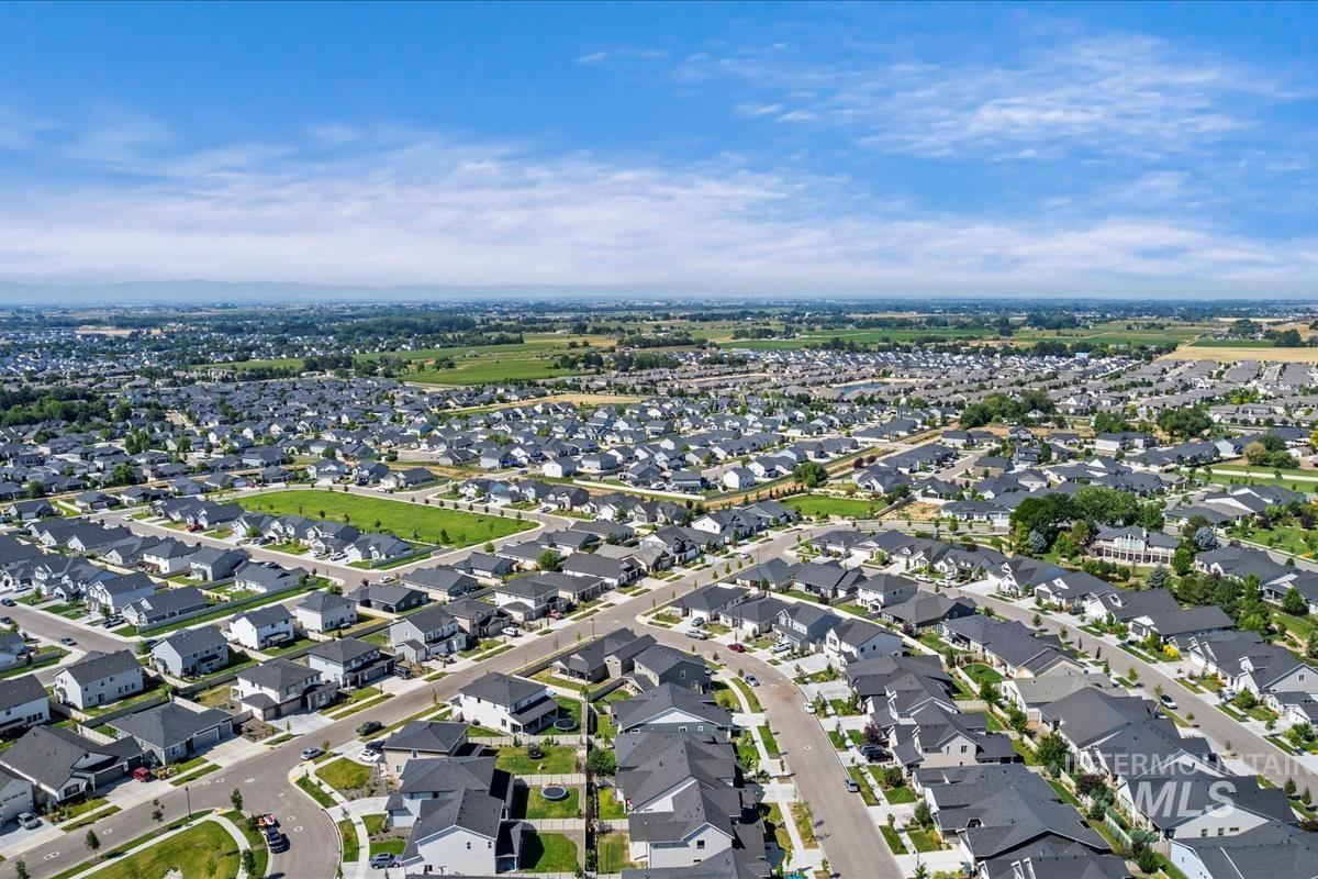 Aerial view of property and surrounding area featuring nearby suburban area