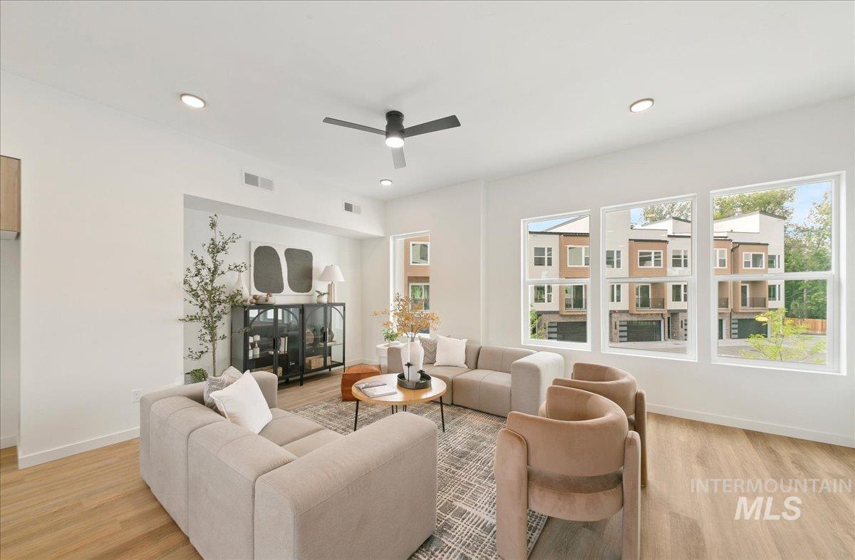 Living area featuring a ceiling fan, recessed lighting, and light wood-type flooring
