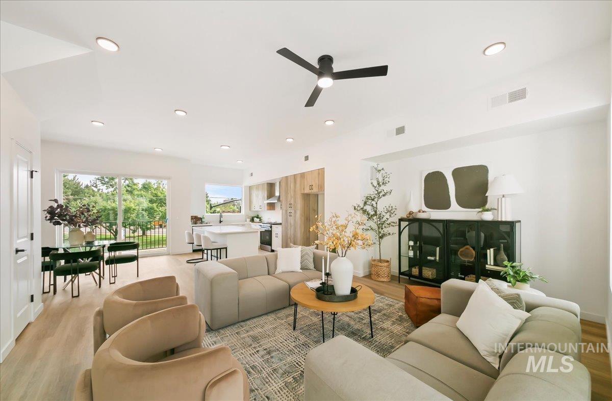 Living room with light wood-type flooring, a ceiling fan, and recessed lighting