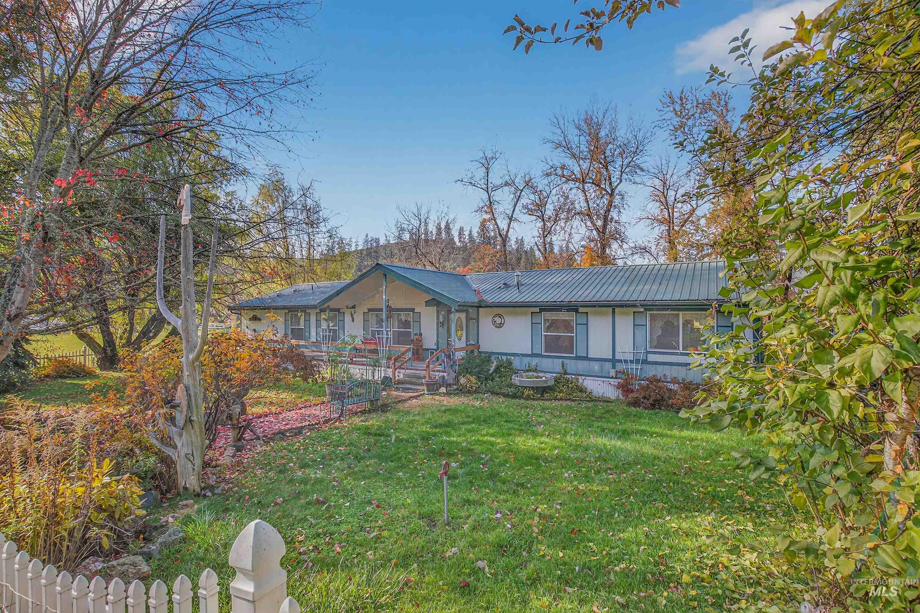 View of front of property with a front yard, a metal roof, and covered porch