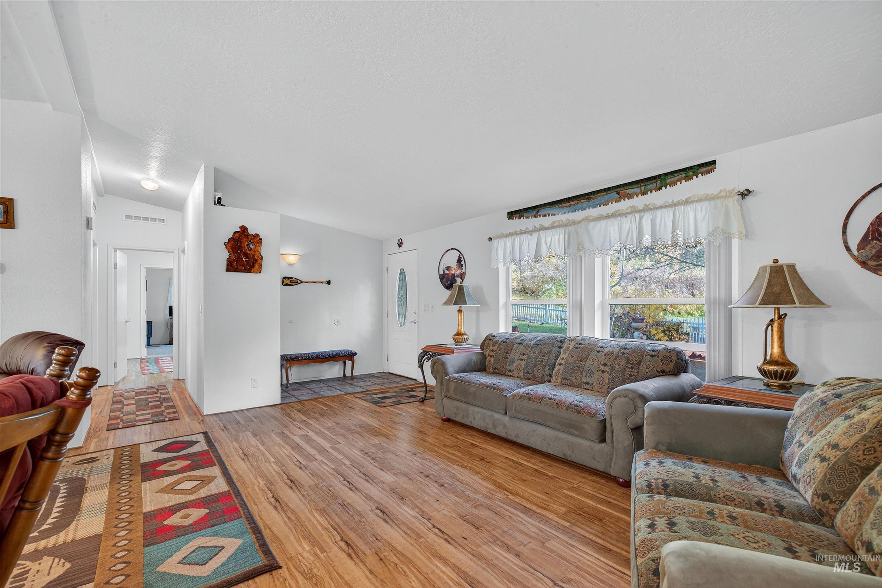 Living area featuring light wood-type flooring and lofted ceiling